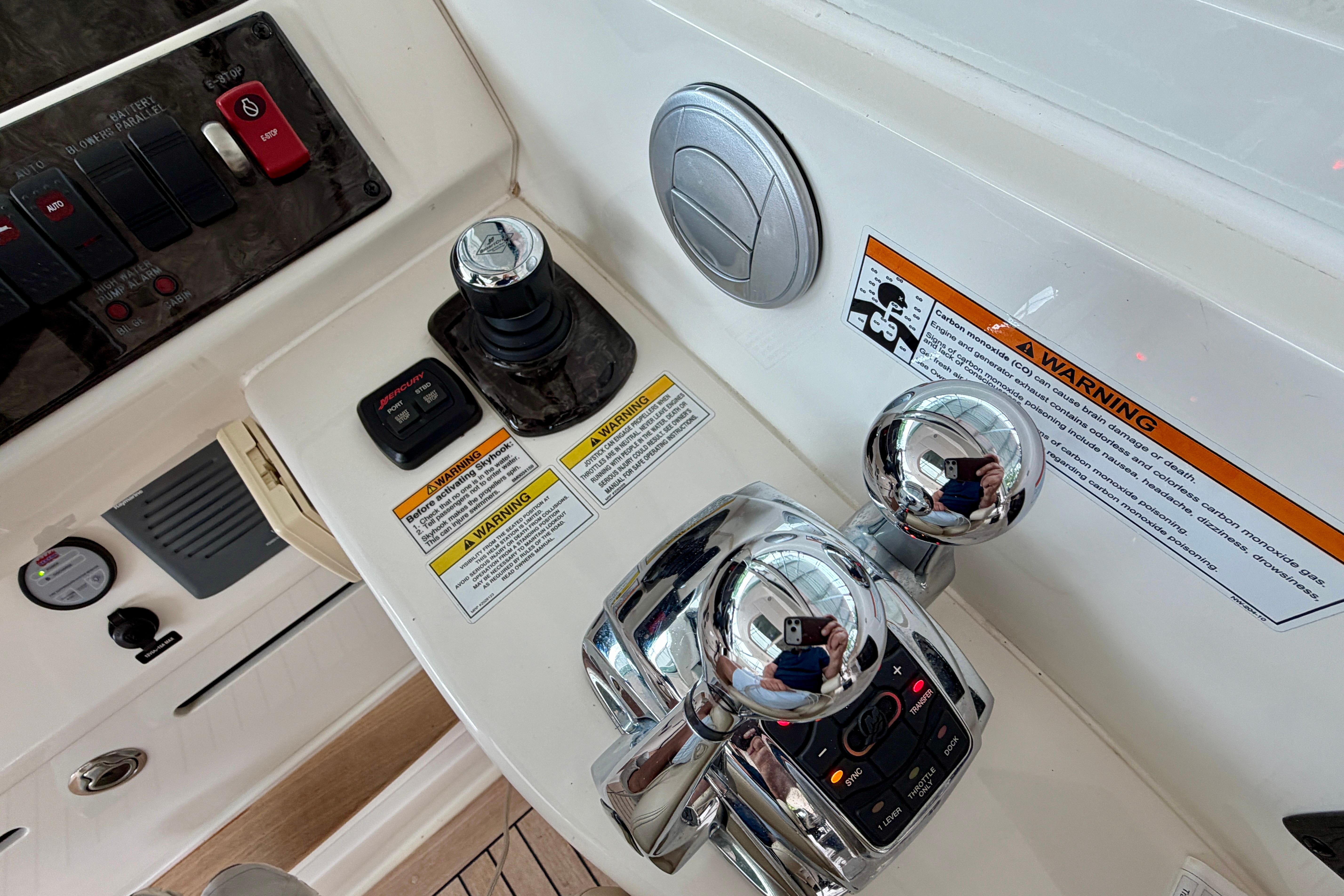 Control panel of a 2012 Sea Ray 450 Sundancer boat with warning labels.