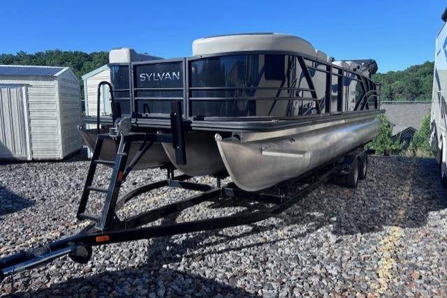 2022 Sylvan L3 DLZ Bar pontoon boat on trailer, parked on gravel lot.