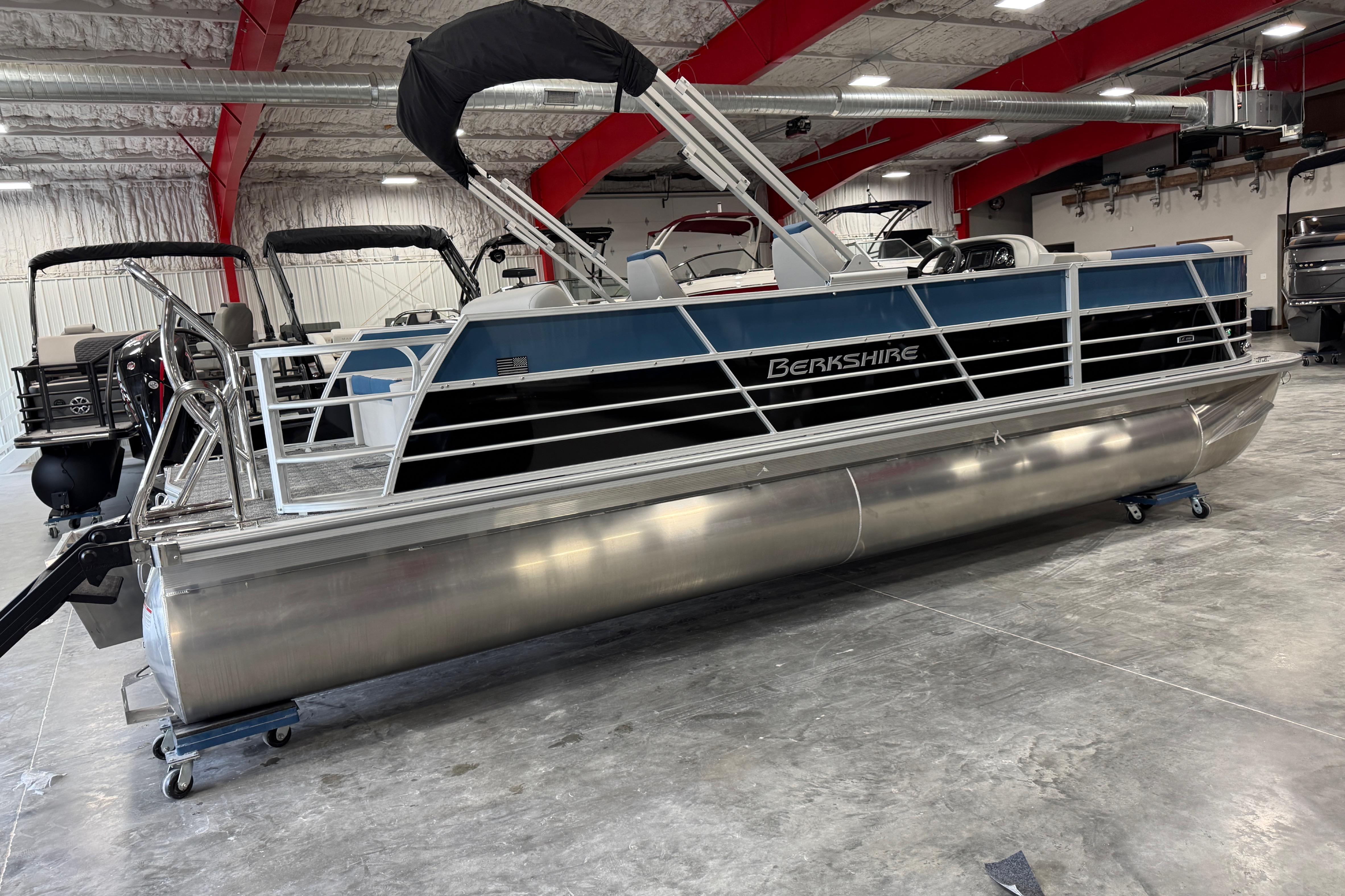 2026 Berkshire 24 UL RE pontoon boat in a showroom, featuring sleek design and modern amenities.