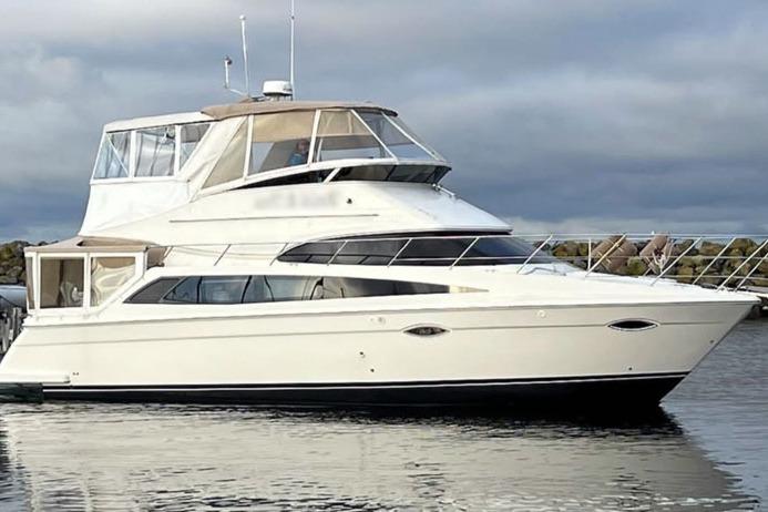 2008 Carver 43 Super Sport yacht on calm water under cloudy sky.