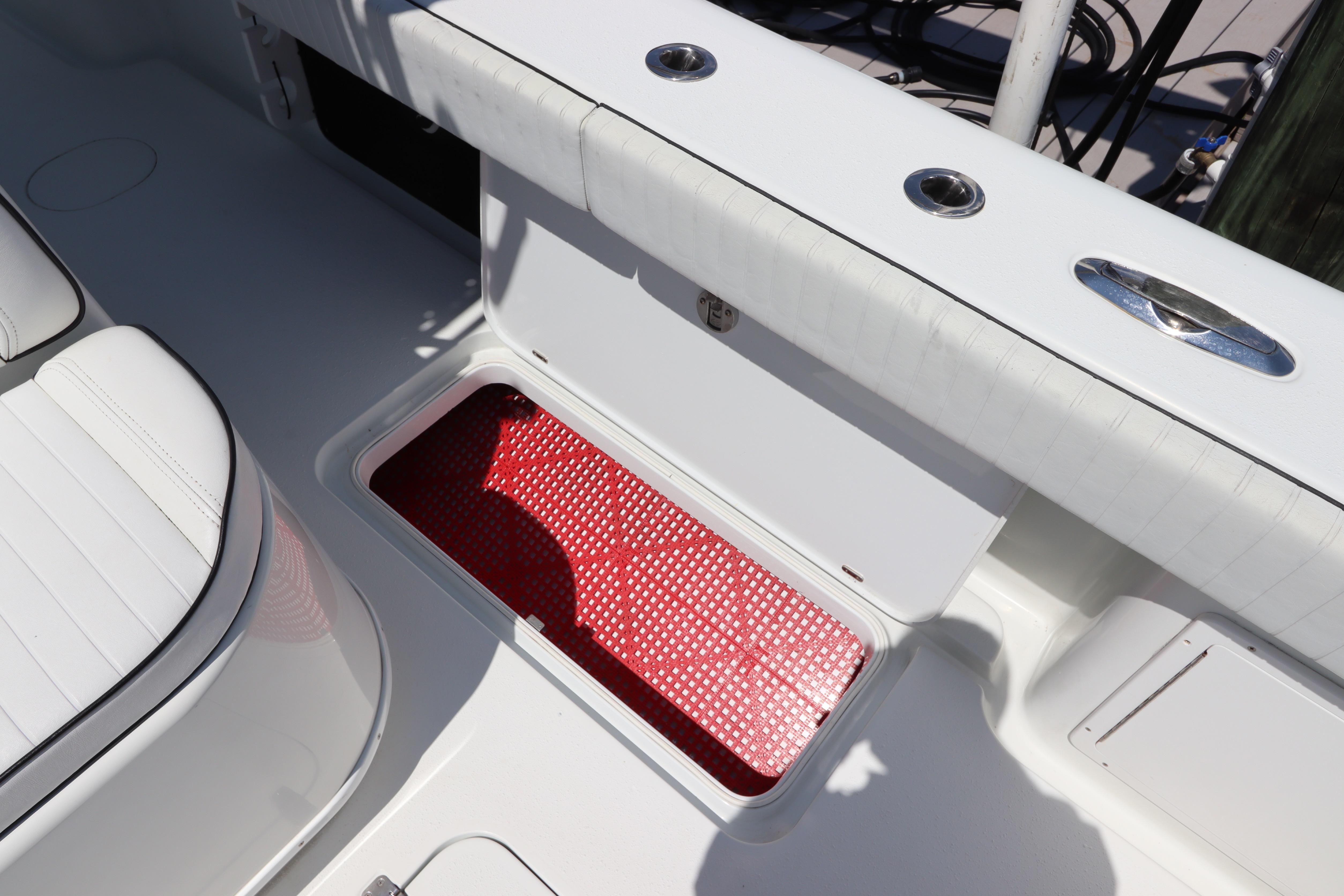 2013 Yellowfin 32 Offshore boat with open storage compartment and red mat.