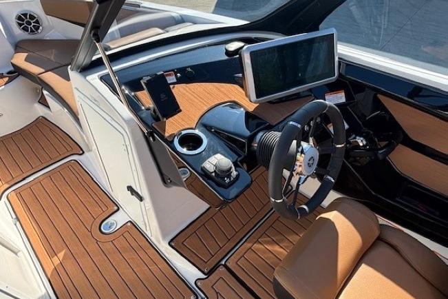 2026 Yamaha Boats 222SE interior with modern dashboard, steering wheel, and wood-style flooring.