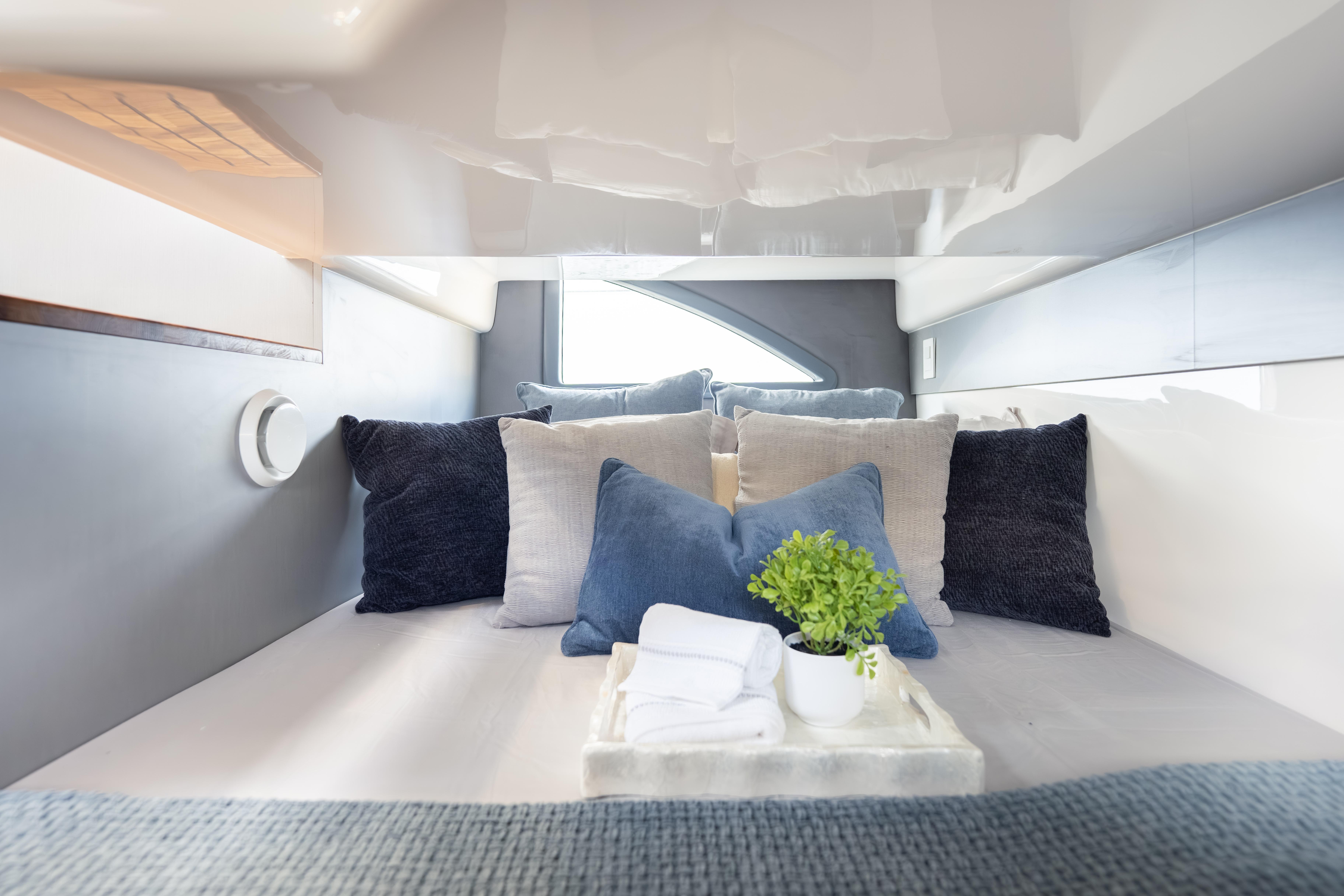 Luxurious cabin interior of 2026 Hanover 347 yacht with plush pillows and decor.