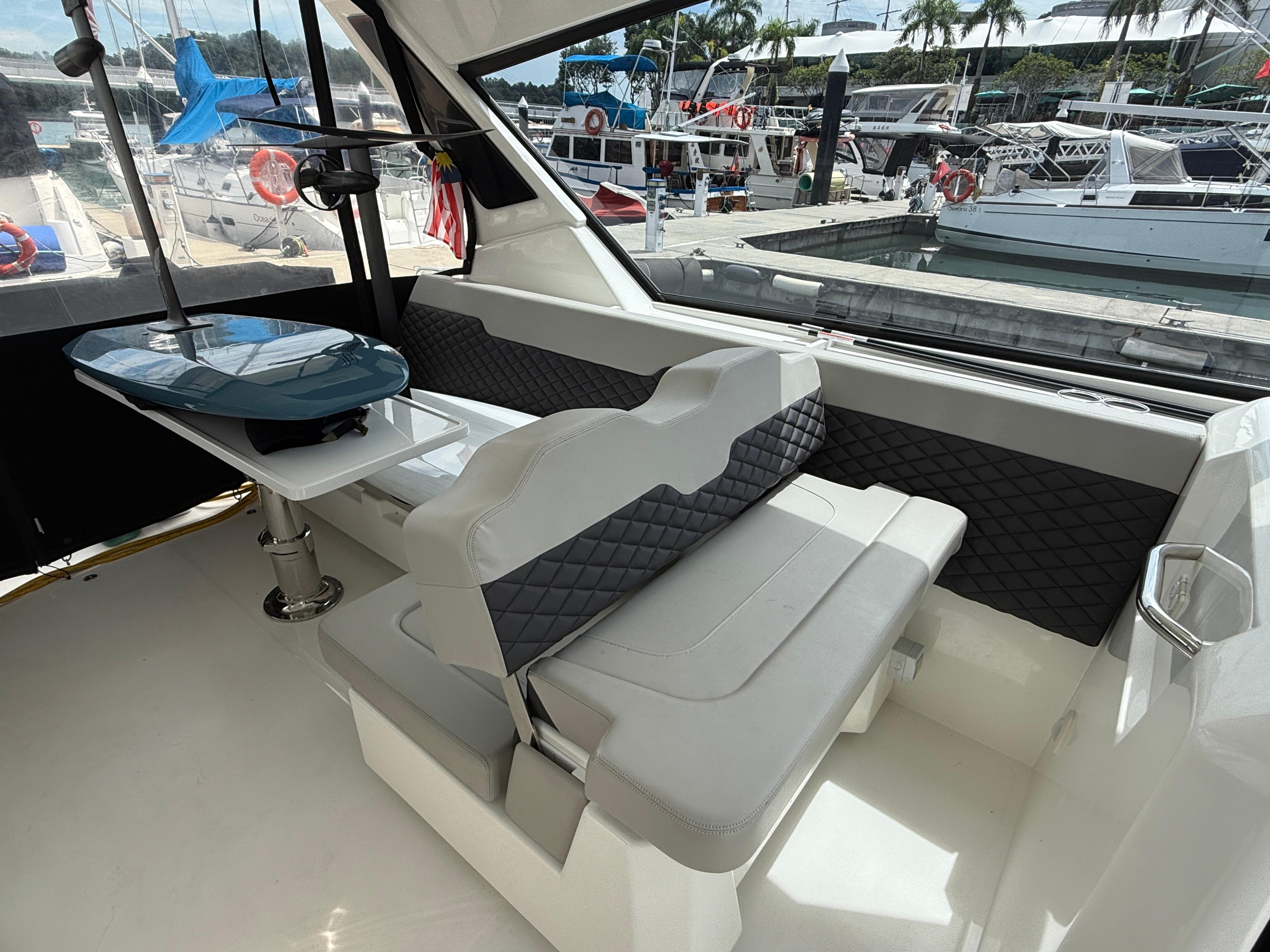 Interior of 2022 Aquila 36 Sport yacht with seating and table, docked at marina.