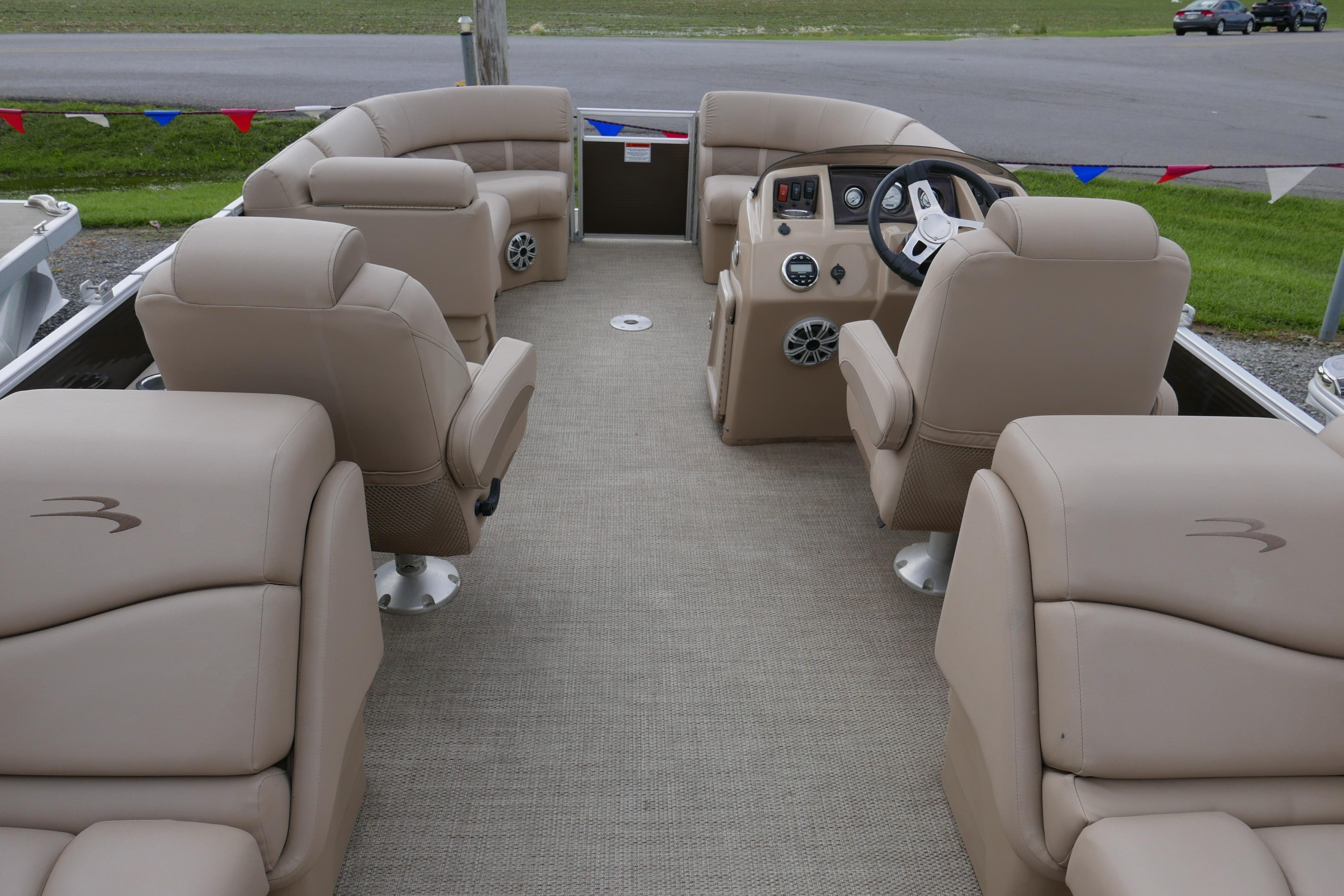 2018 Bennington 22 SSRX pontoon boat interior with beige seating and steering console.