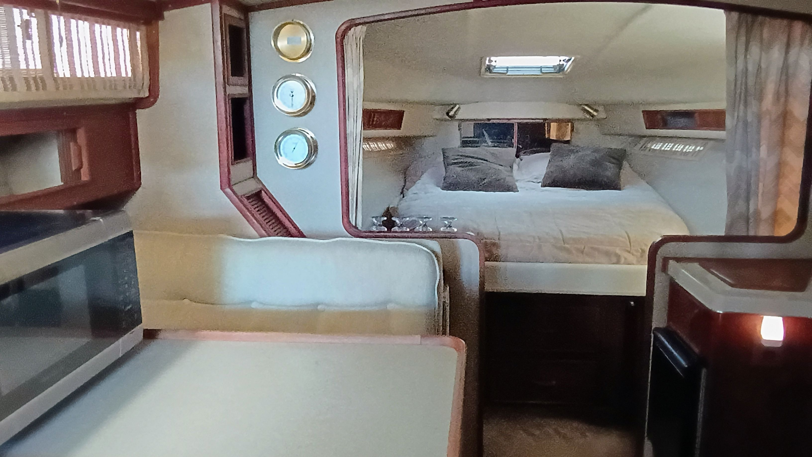 Interior of a 1986 Sea Ray Sundancer with a cozy bed and wooden furnishings.