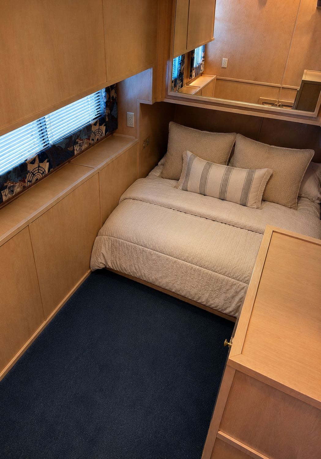 The image shows a cozy bedroom with a double bed, wooden walls, and a window with blinds.
