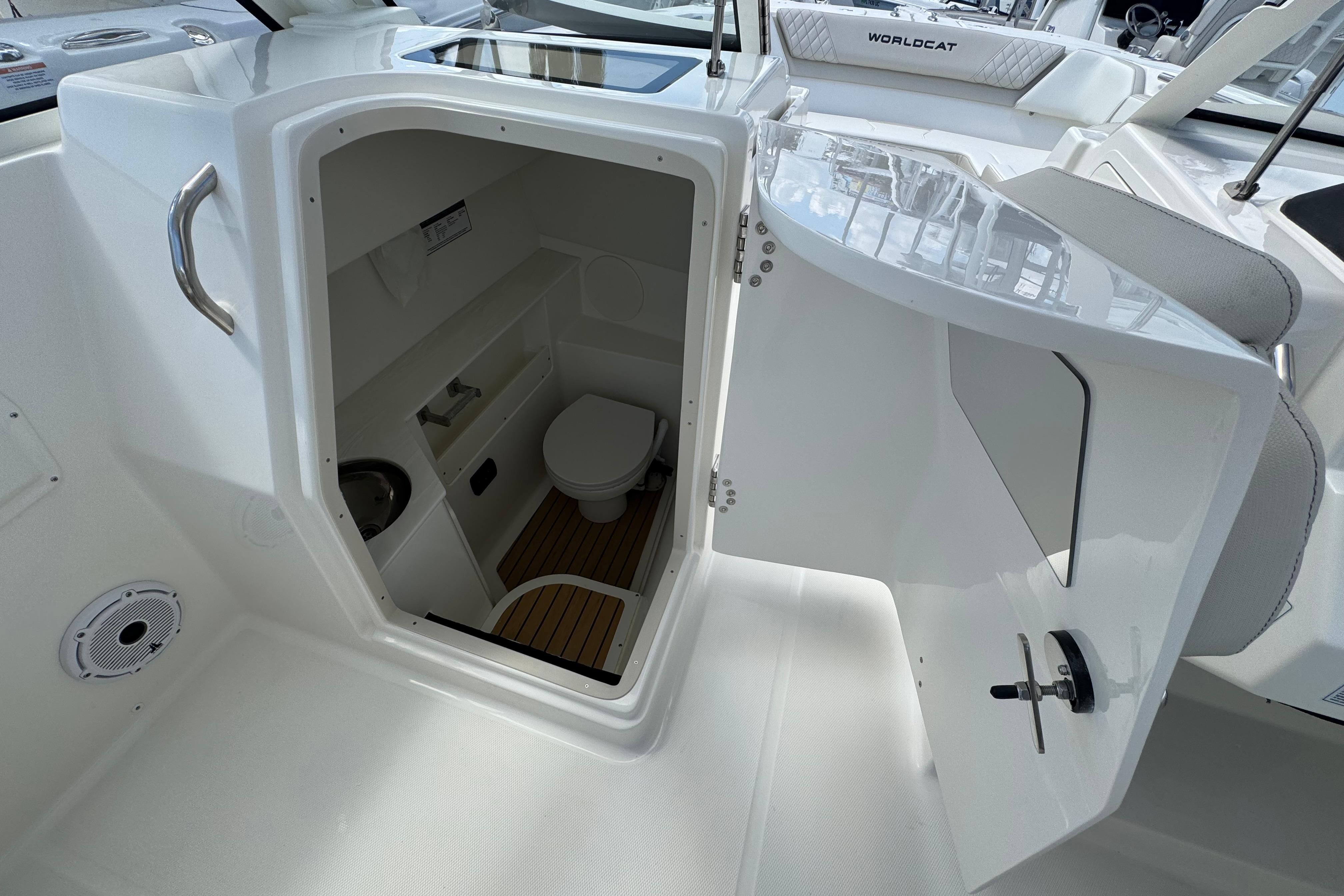 Interior view of 2026 World Cat 280 DC-X boat's compact bathroom with toilet and sink.