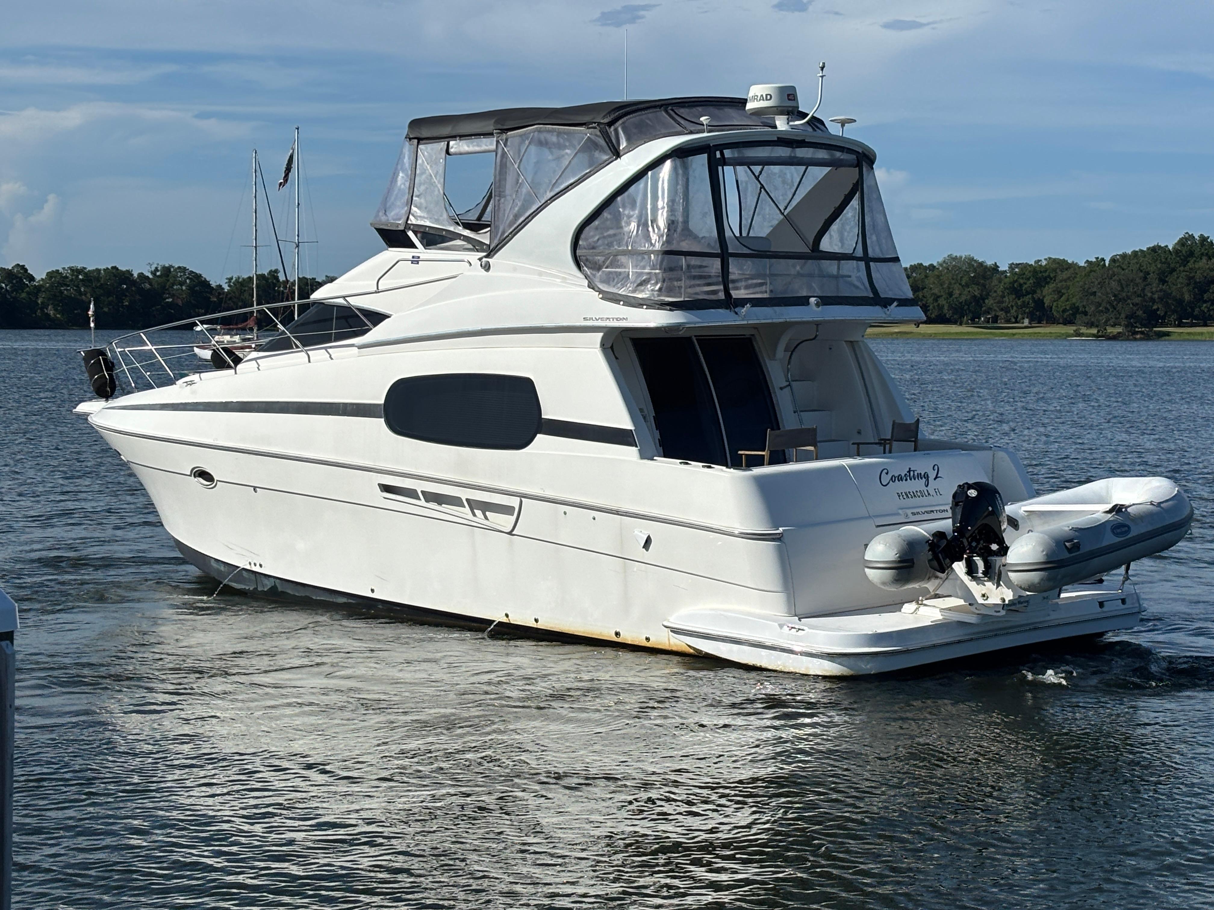 2001 Silverton 410 Sport Bridge yacht on calm water, featuring a sleek design and spacious deck.