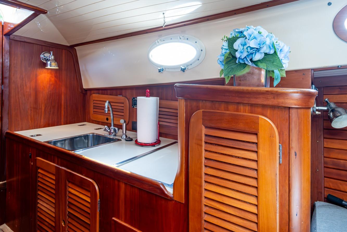2001 Hinckley Picnic Boat Classic interior with wooden cabinetry and sink.