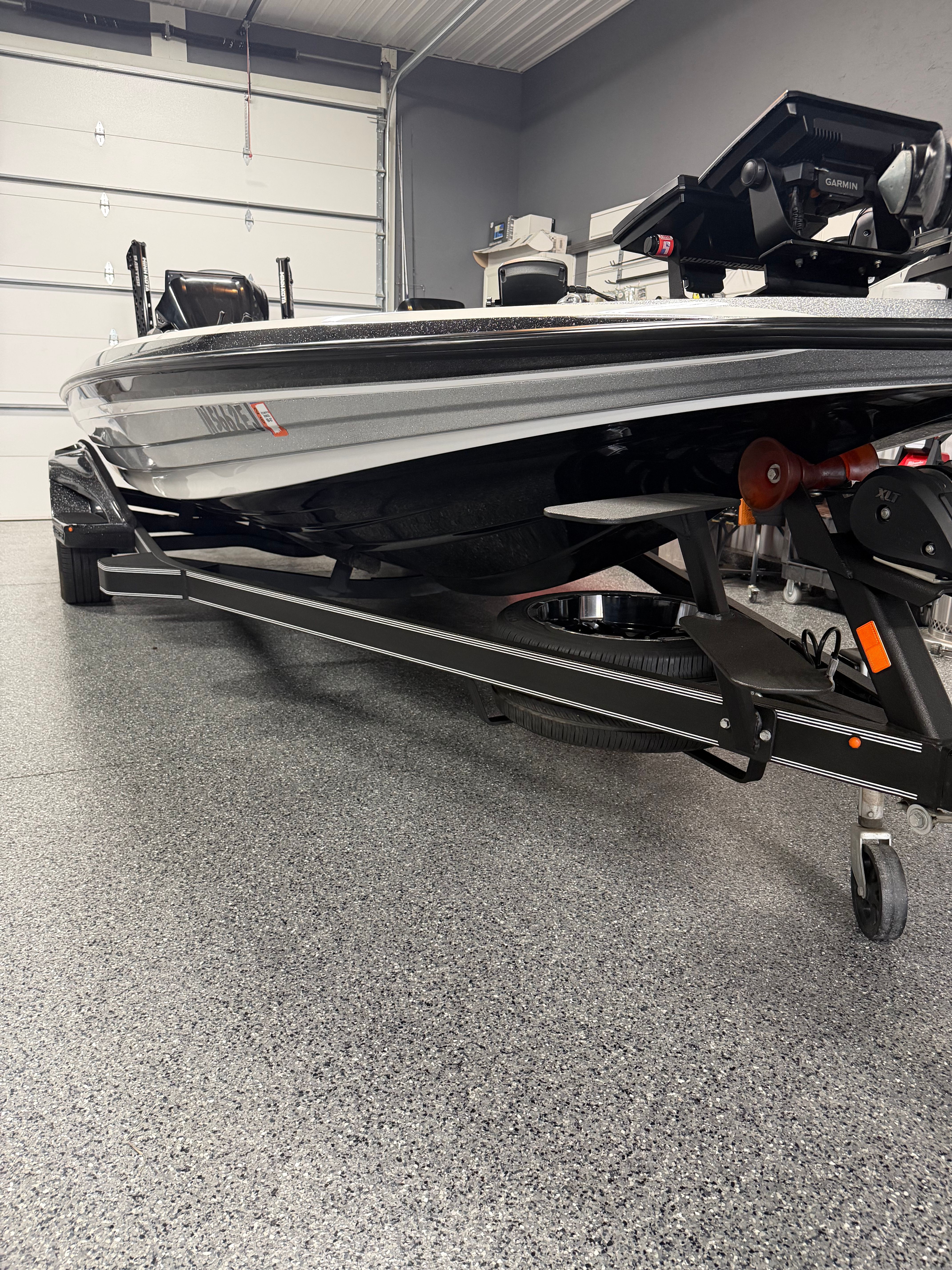 A 2022 Skeeter FXR21 Limited boat is in a garage on a trailer.