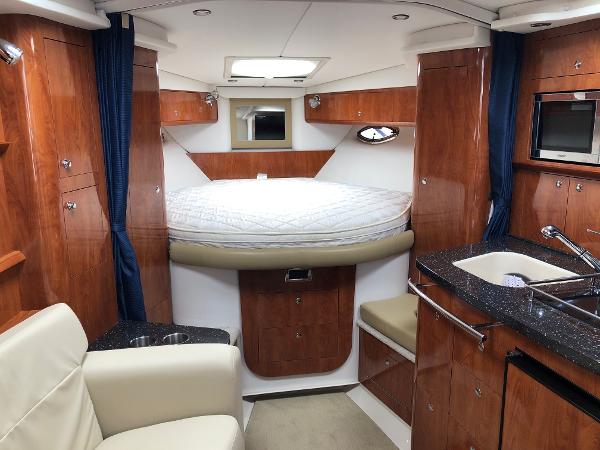 Interior of the 2008 Four Winns V338 with cozy bed and elegant wood finish.