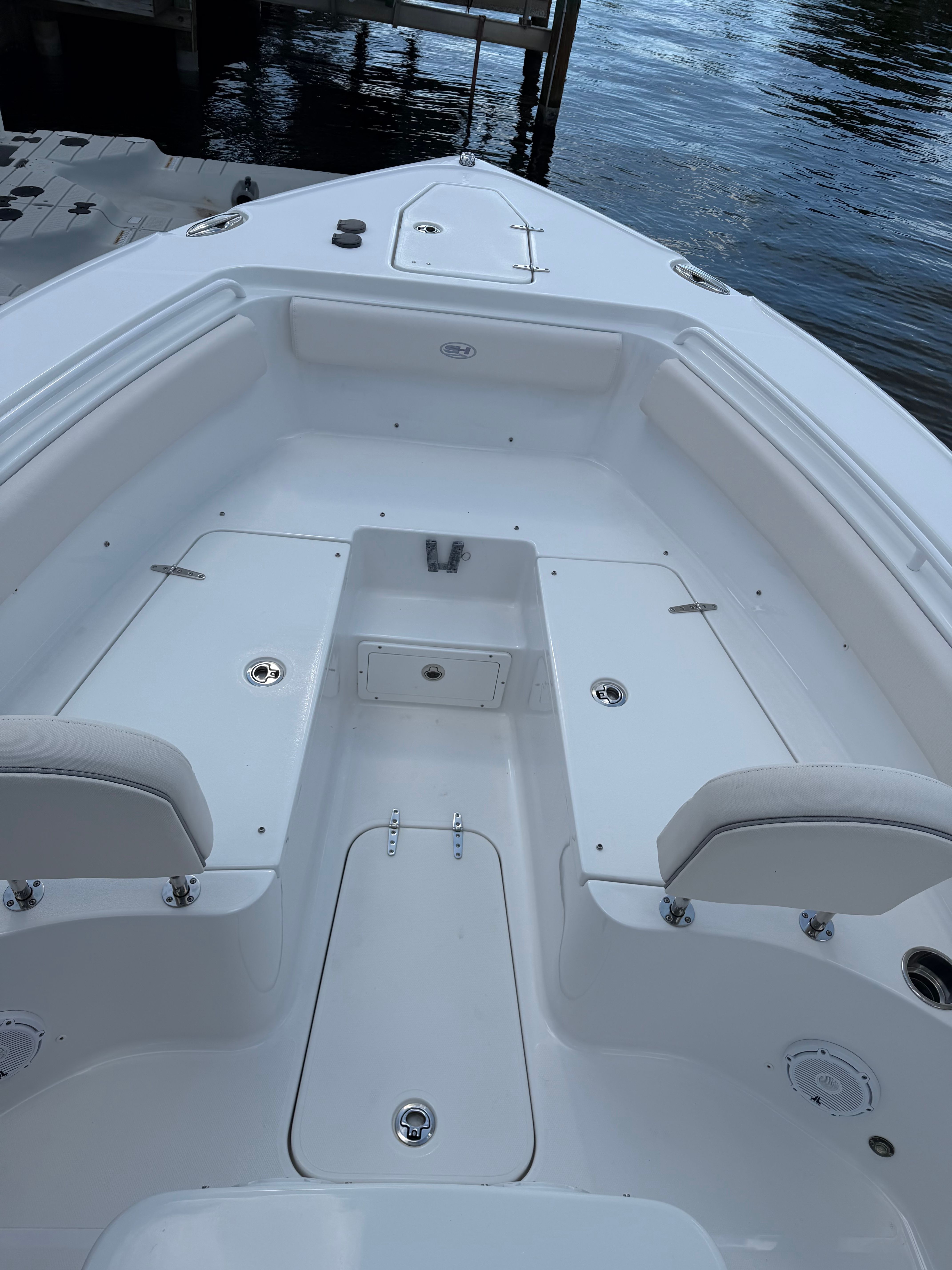 The image shows the bow area of a Sea Hunt Ultra 265 SE boat docked.
