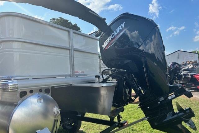 2026 Sun Tracker Party Barge 18 DLX with Mercury outboard motor, parked on grass.