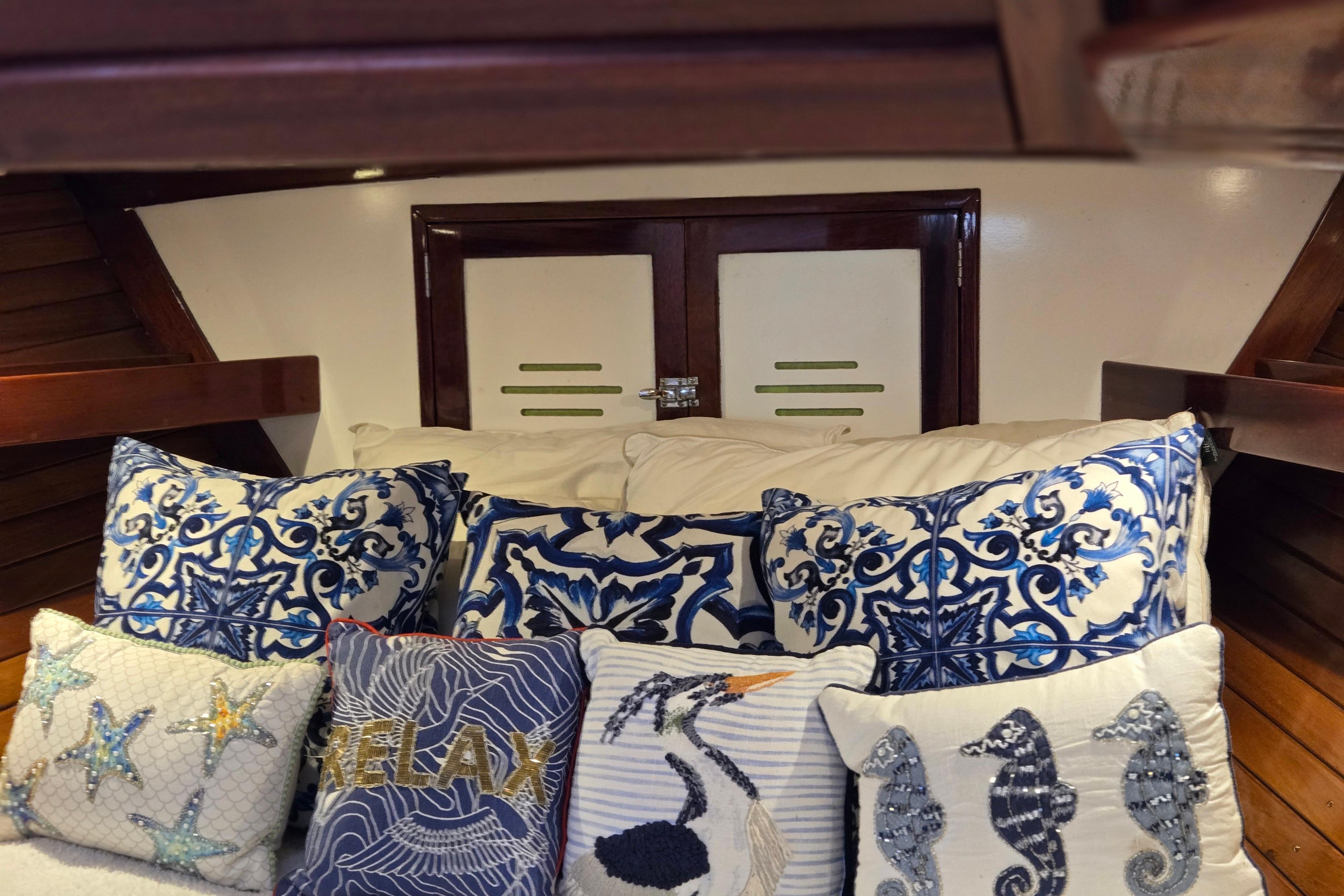 Cozy cabin interior of 1970 Hinckley Bermuda 40 with nautical-themed pillows.