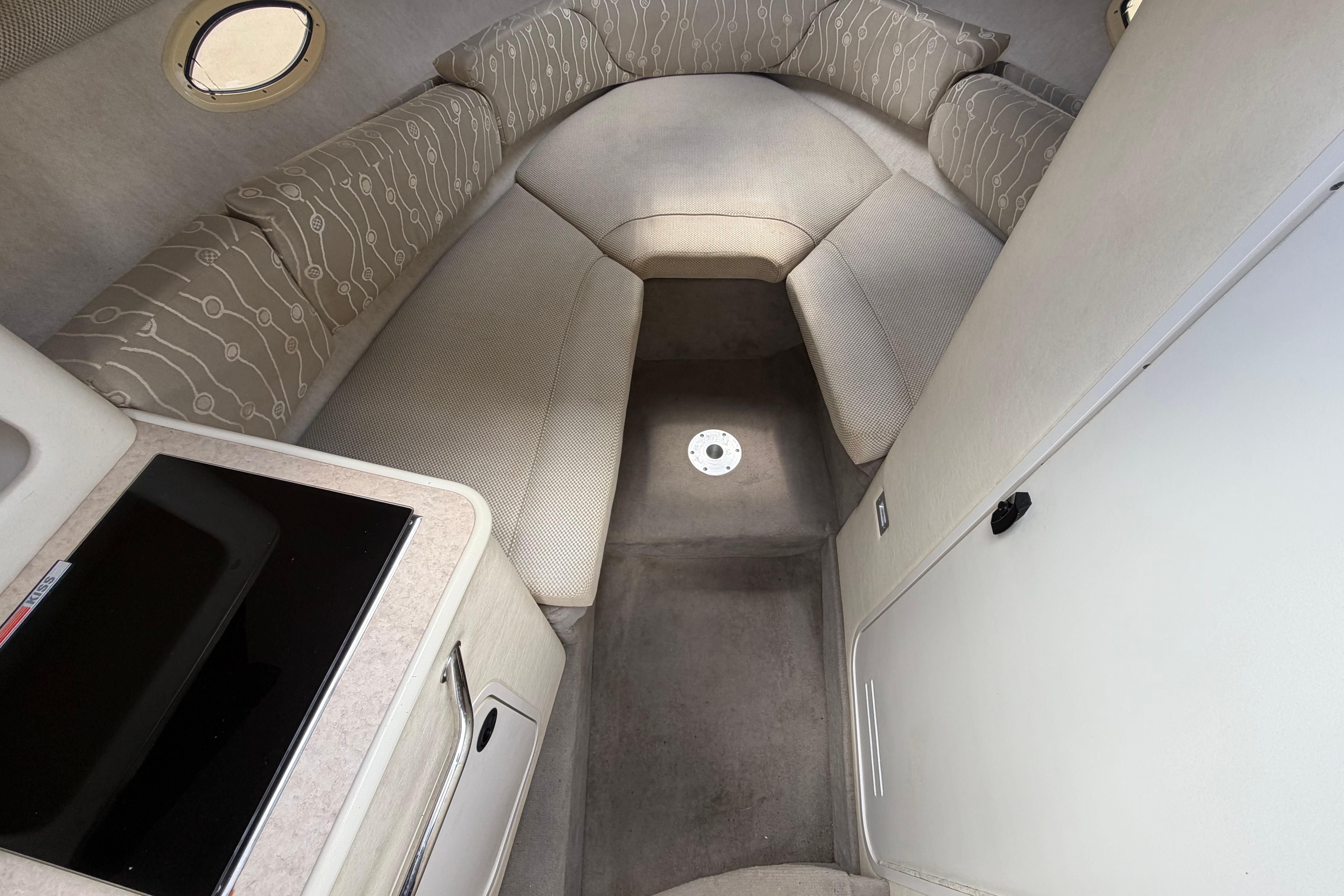 Interior cabin of 2006 Sea Ray 250 Amberjack boat with seating and kitchenette.
