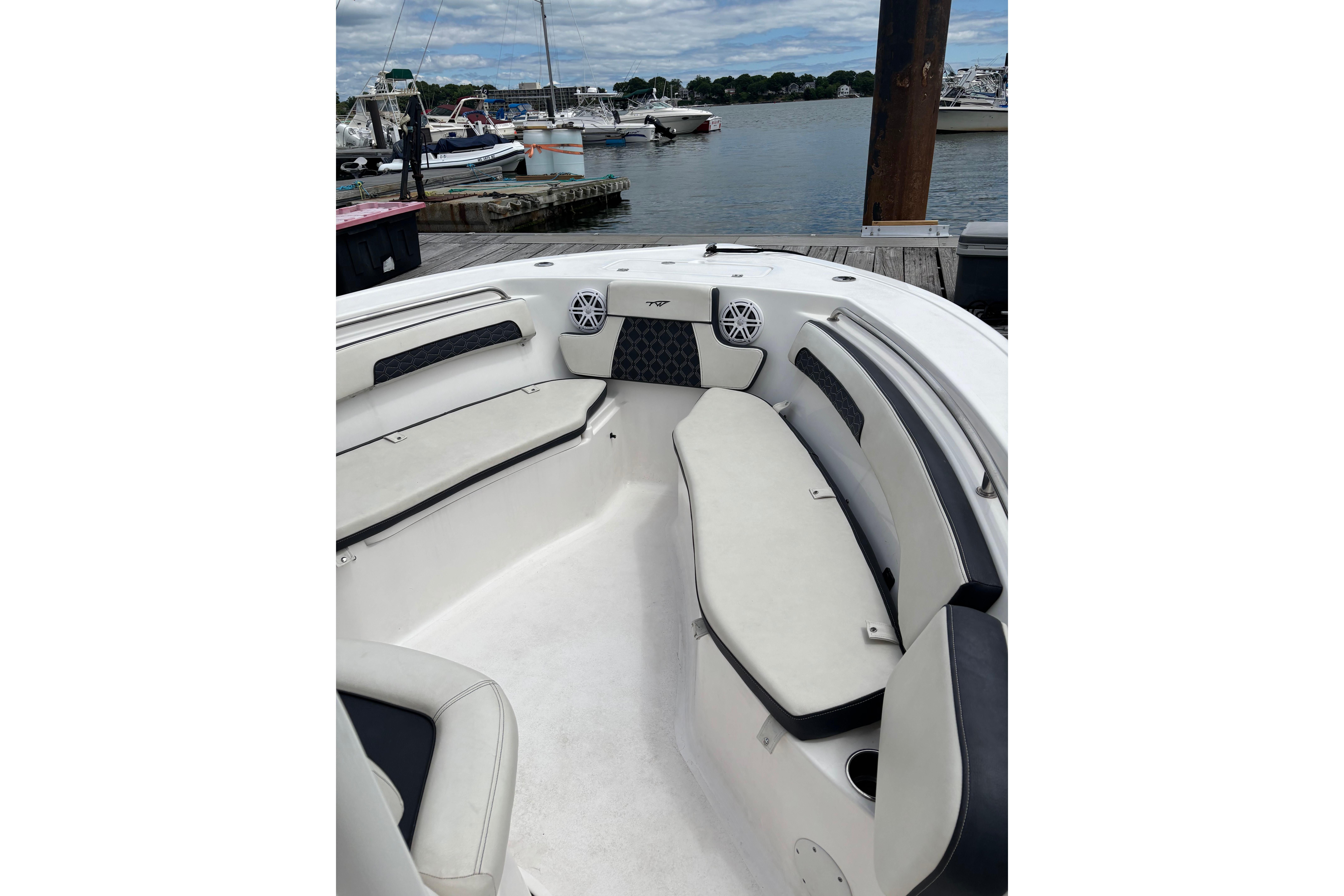 2024 Tidewater 220 CC Adventure boat interior with cushioned seating at a marina.