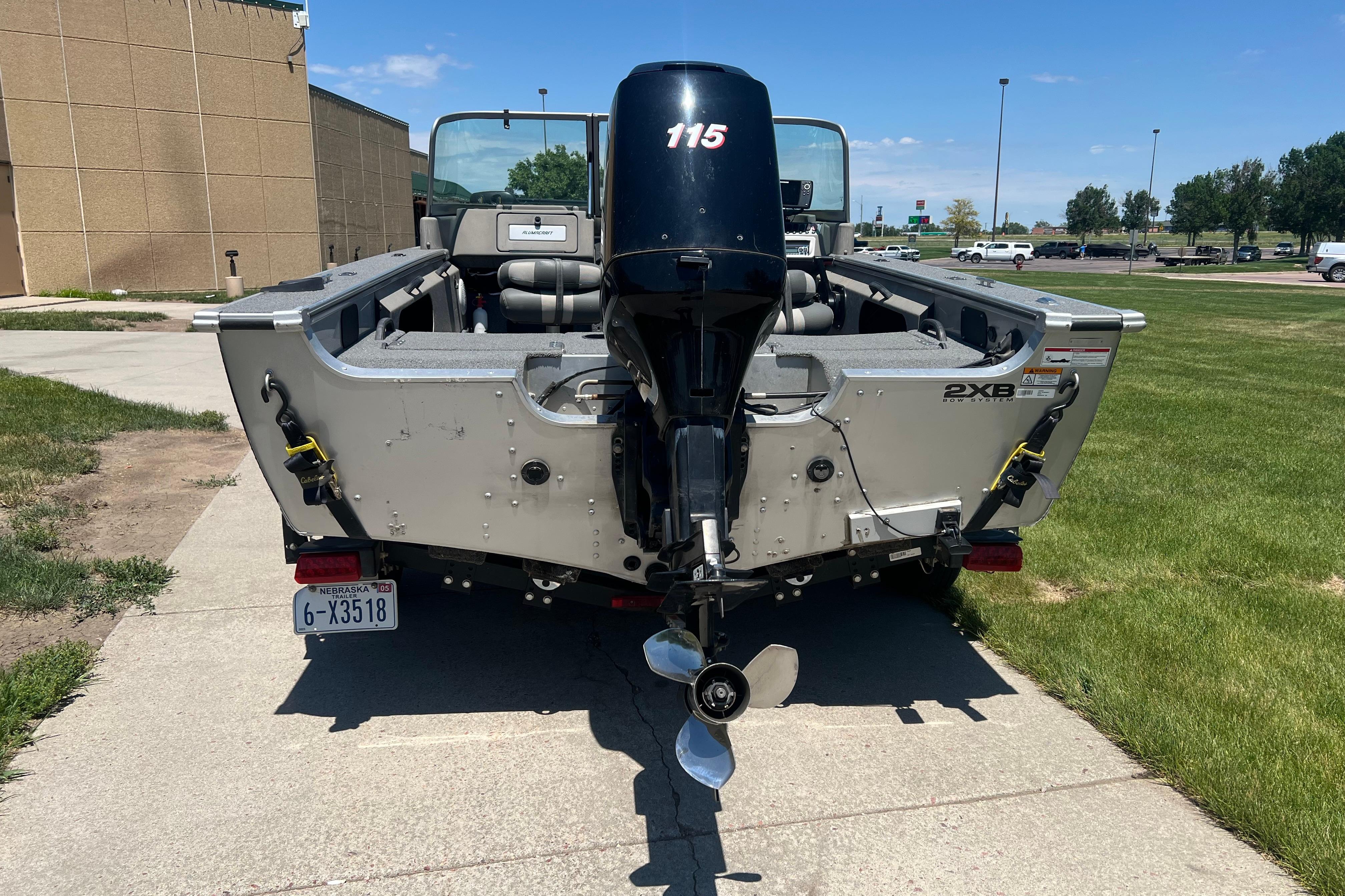 2010 Alumacraft Dominator 165 Sport boat with outboard motor, parked on a sunny day.