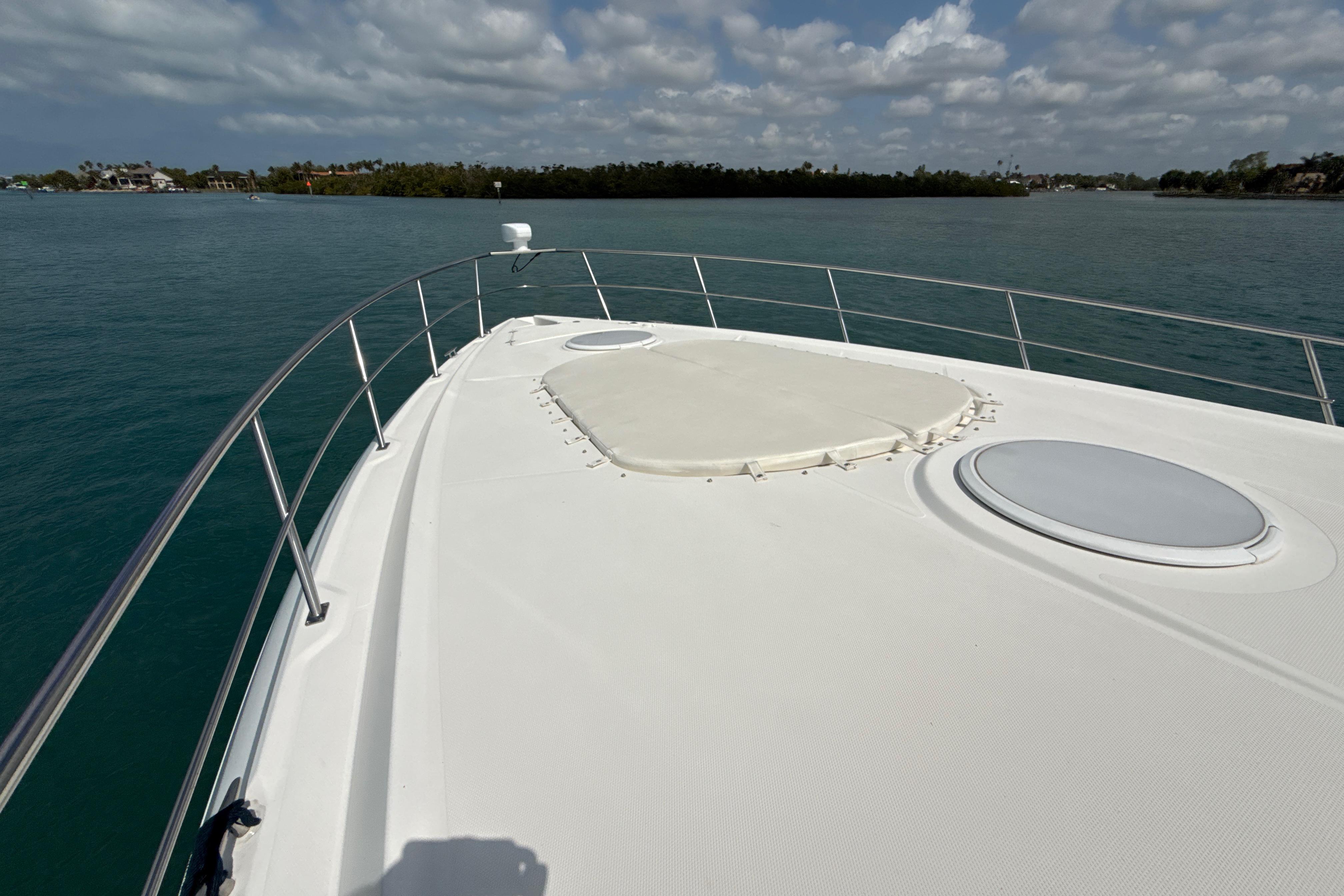 2006 Cruisers Yachts 420 Express bow view on calm water under cloudy sky.