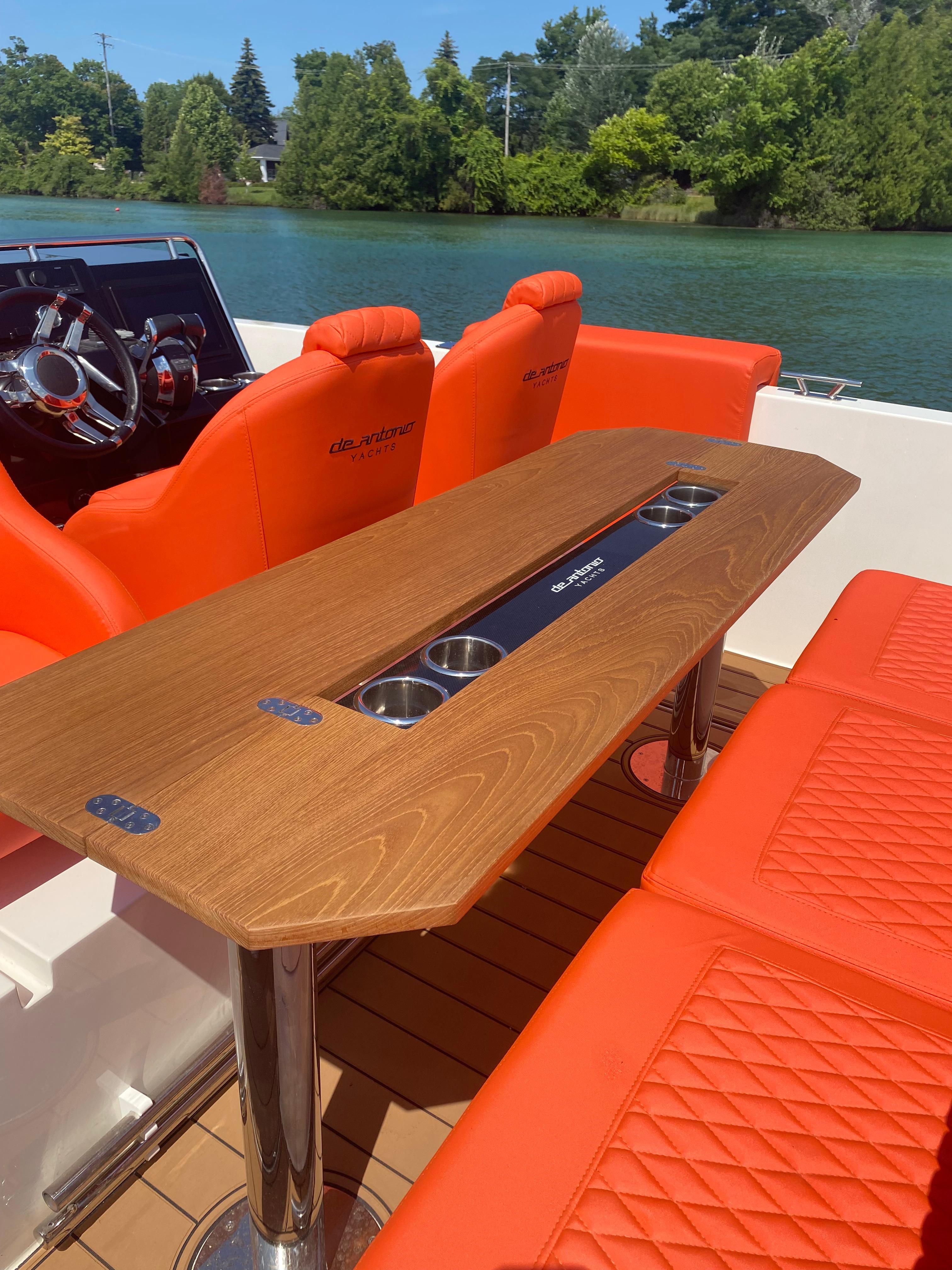 De Antonio Yachts D 28 2020 model with orange seating and wooden table on a serene lake.
