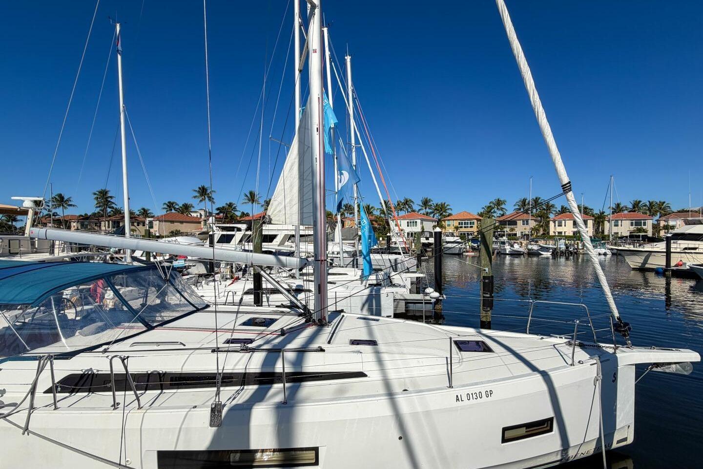 2022 Beneteau Oceanis 40.1 sailboat docked in a sunny marina with palm trees.