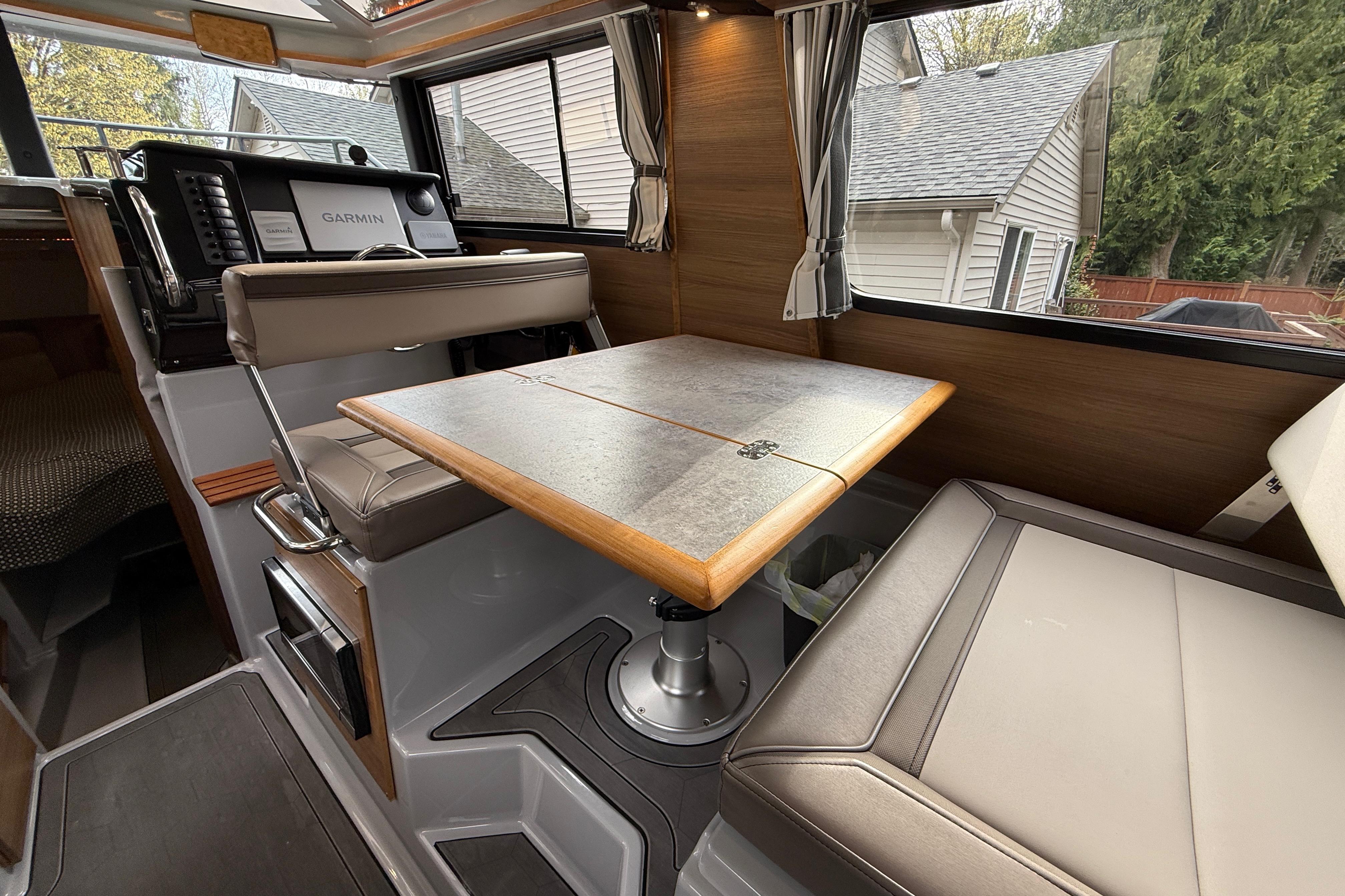 2024 Ranger Tugs R-27 interior with dining table and navigation equipment.
