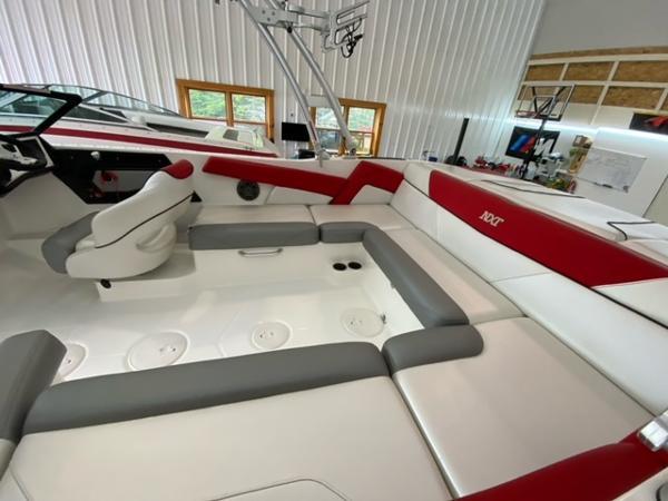 2017 MasterCraft NXT22 boat interior with red and gray seating in a spacious garage.