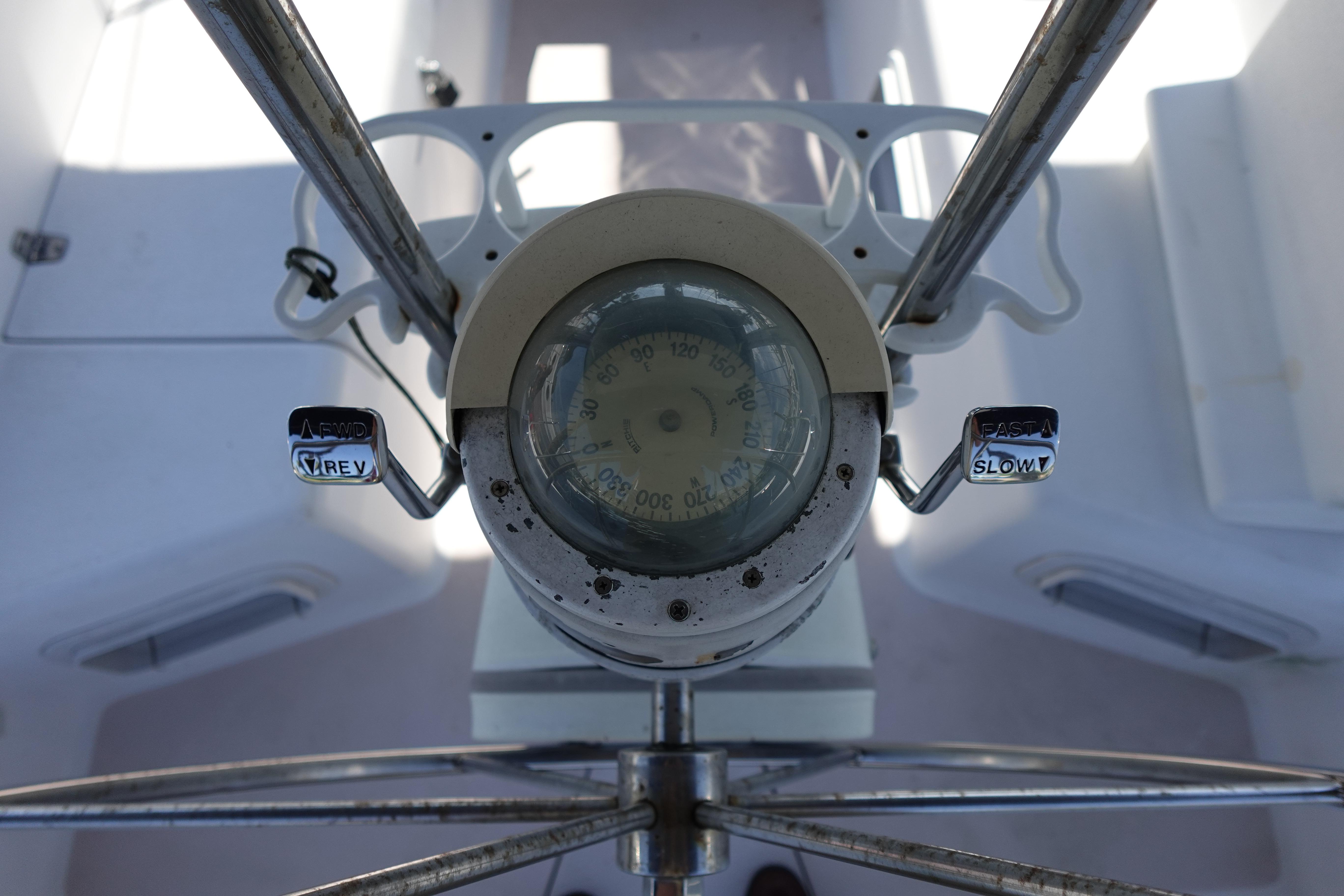 Steering wheel and compass of a 1997 Catalina 28 sailboat cockpit.