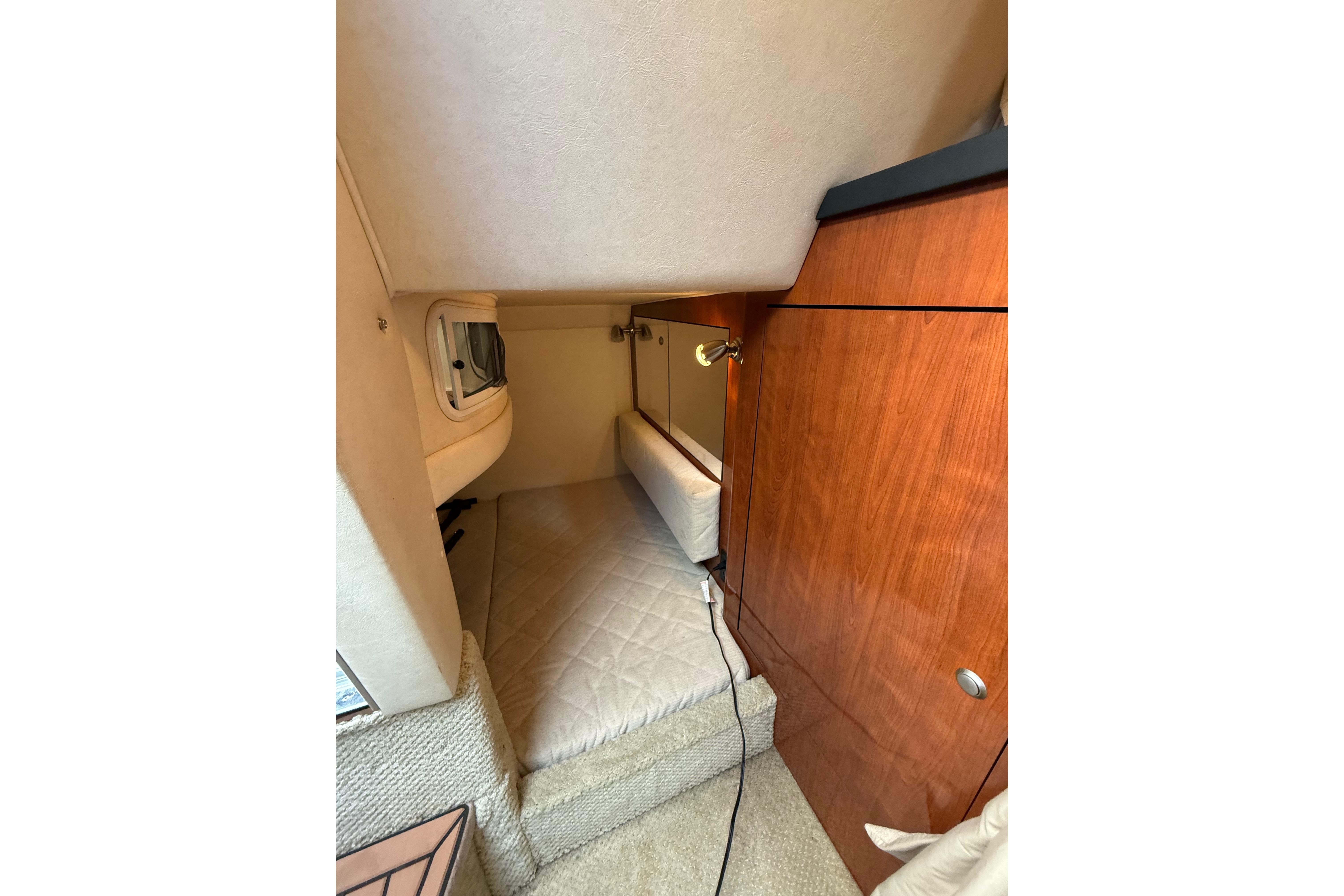 2007 Sea Ray 280 Cuddy Cabin interior with cozy sleeping area and wooden cabinetry.