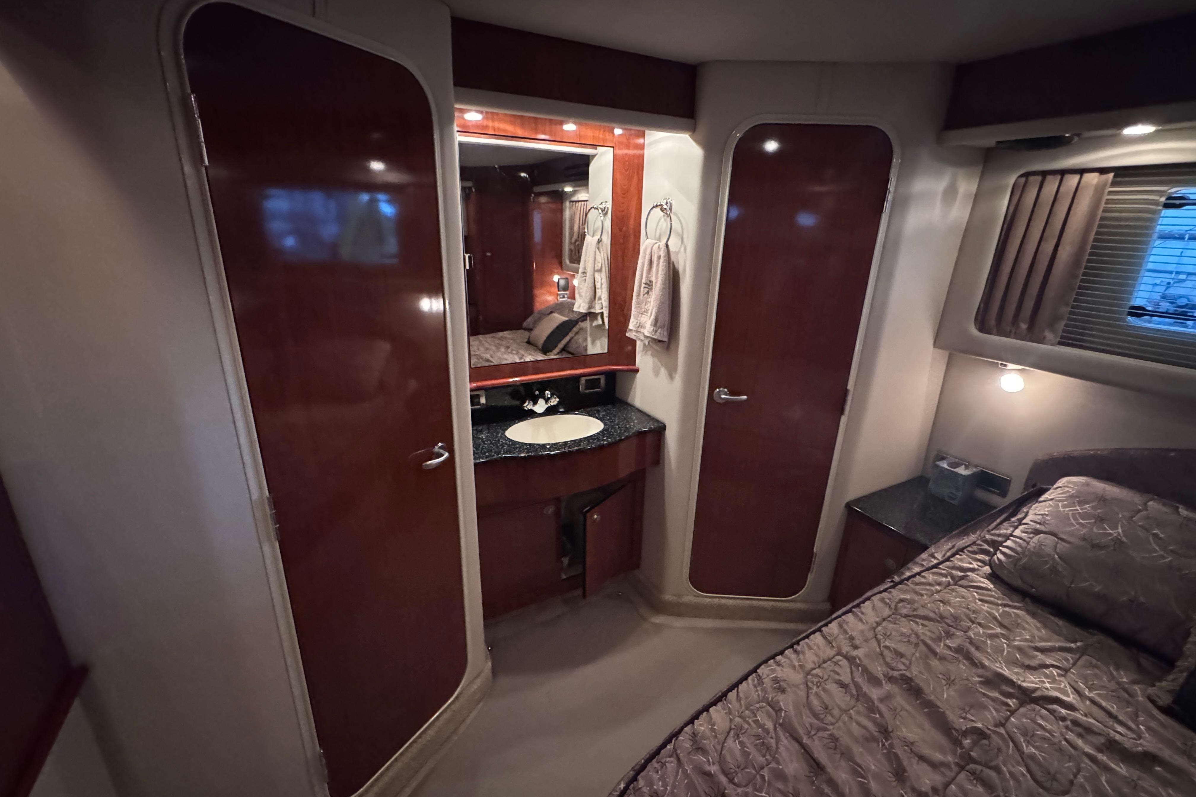 Luxurious 2004 Sea Ray 390 Motor Yacht interior with elegant wood finishes and cozy bedroom.