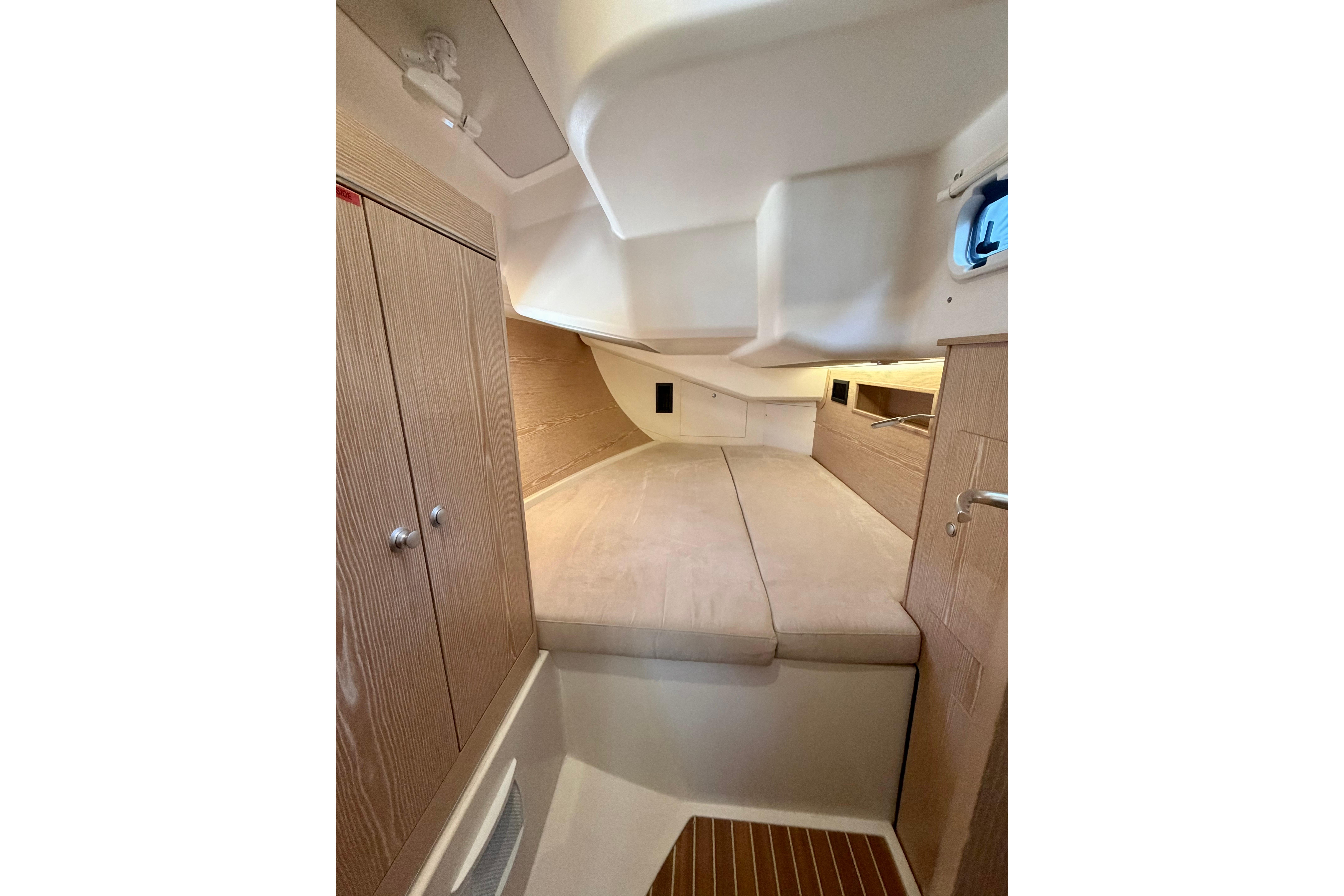 Interior cabin of 2016 Hanse 455 yacht with cozy bed and wooden cabinetry.