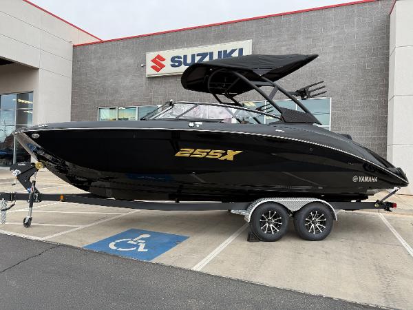 2025 Yamaha Boats 255XD in black, displayed on a trailer outside a Suzuki dealership.