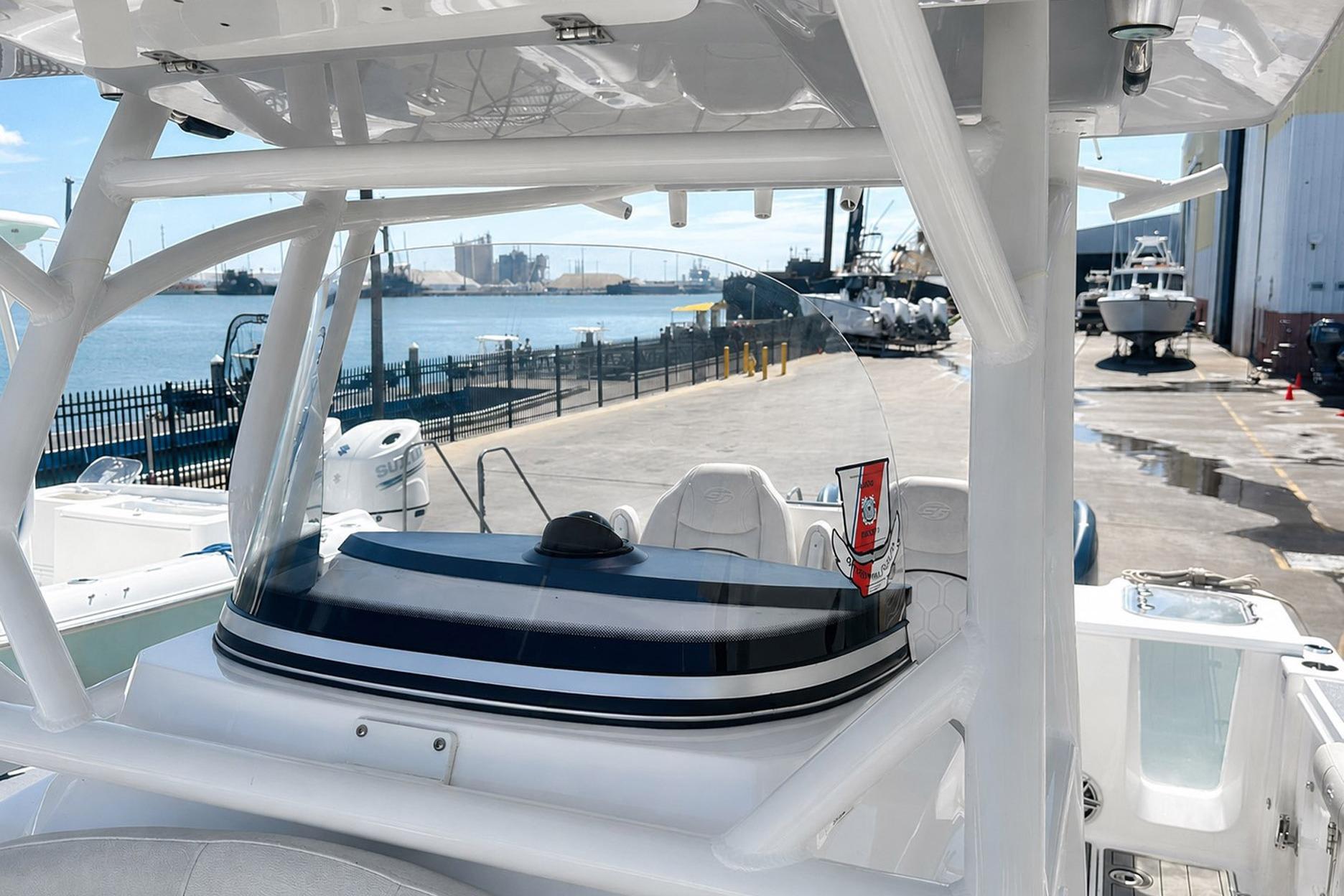 Sea Fox 228 Commander boat docked near waterfront, showcasing helm and seating area.