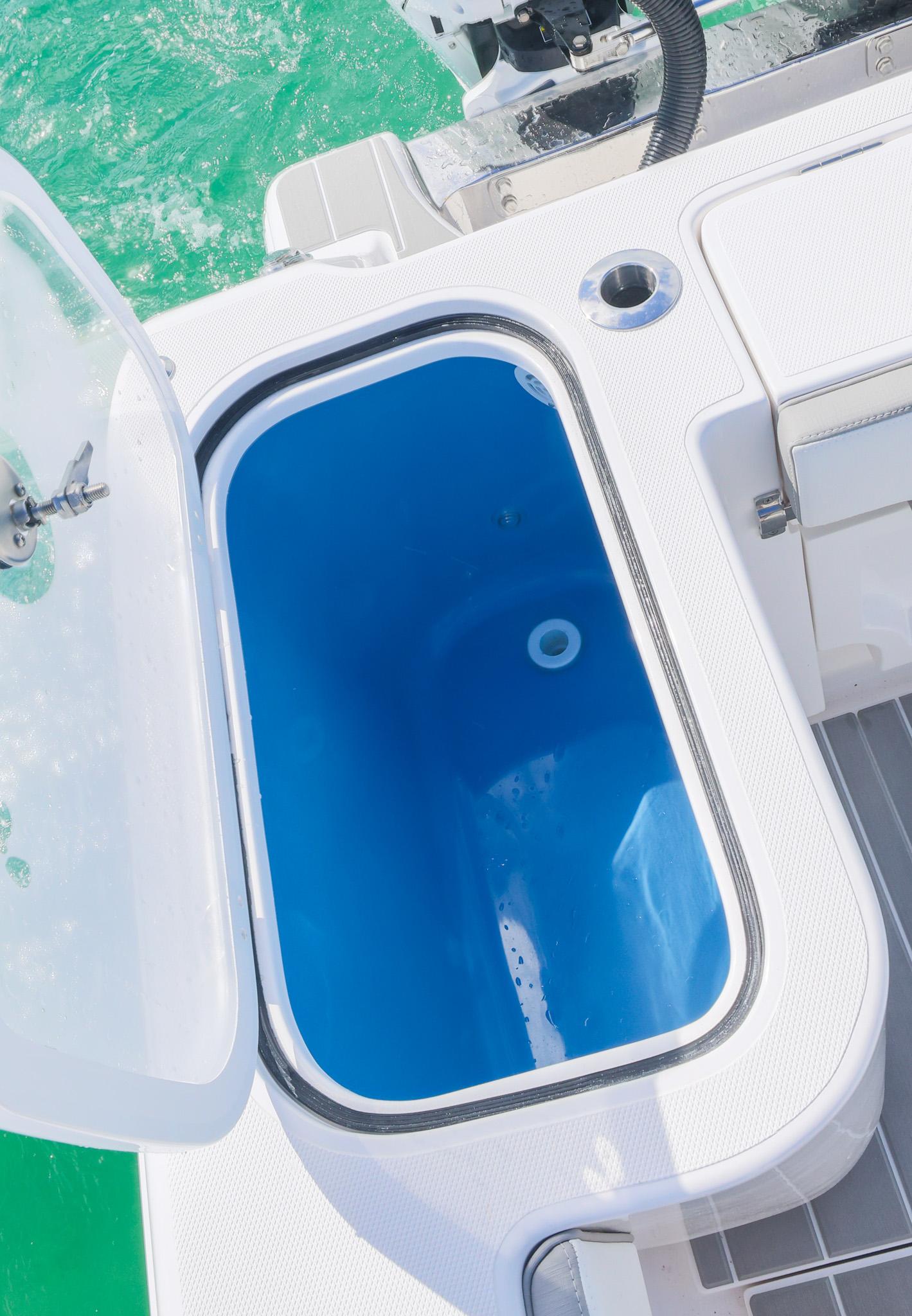 Livewell on 2025 Blackwater 43 Sportfish boat, open lid, blue interior, ocean background.