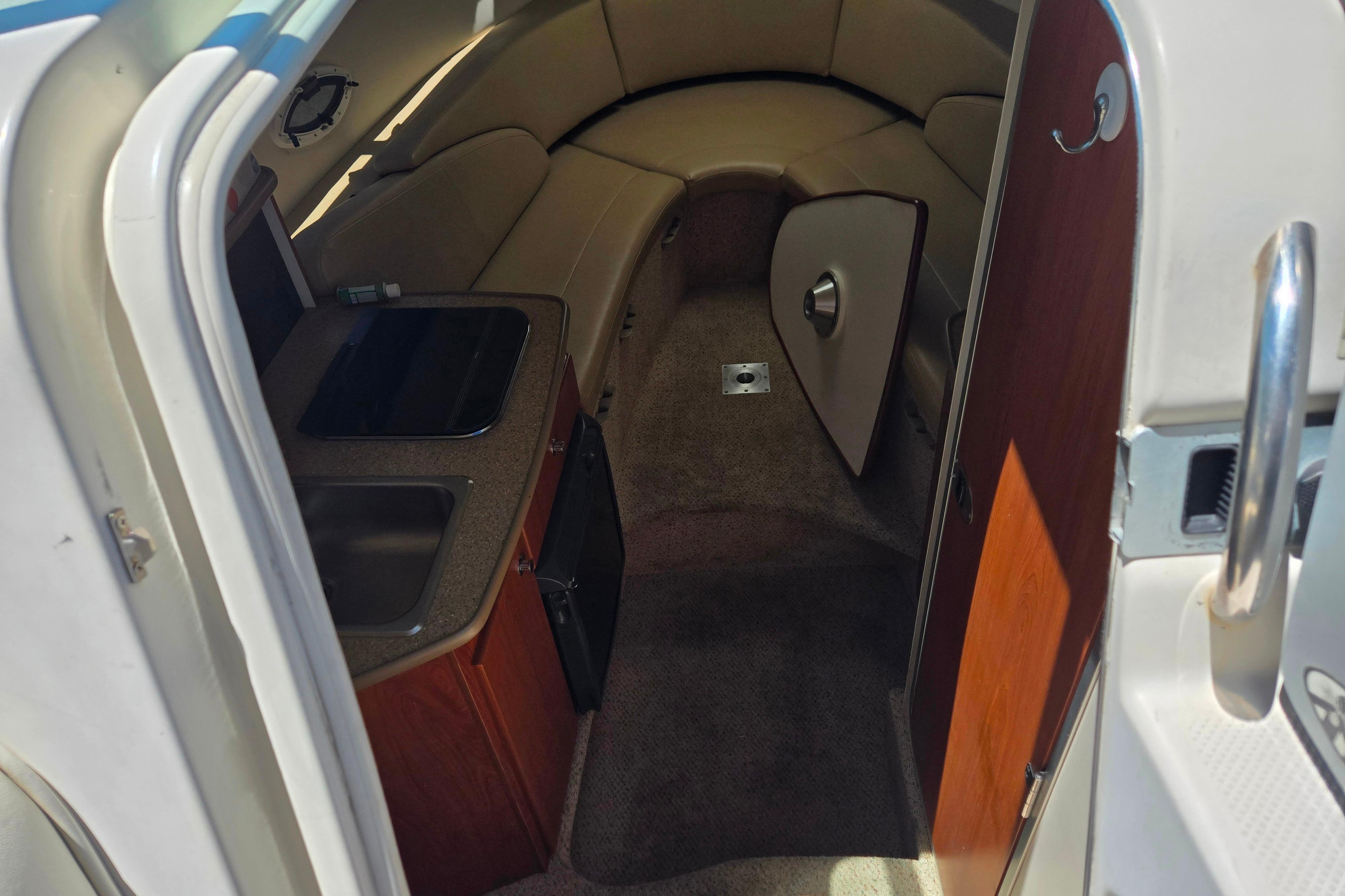 Interior of a 2006 Bayliner 265 boat, featuring a compact kitchenette and seating area.