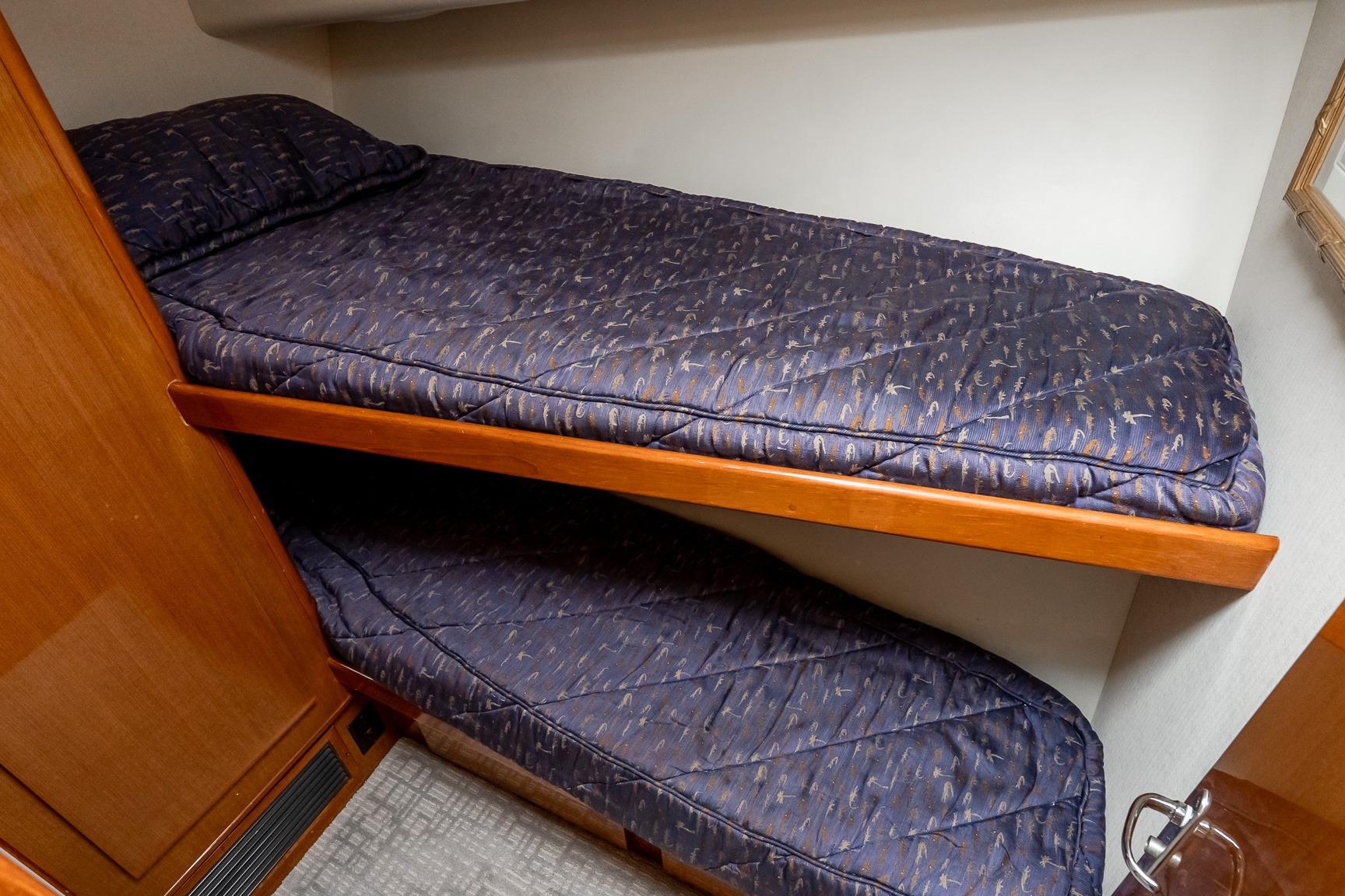Bunk beds in 2000 Viking 50' Convertible yacht cabin with blue bedding.