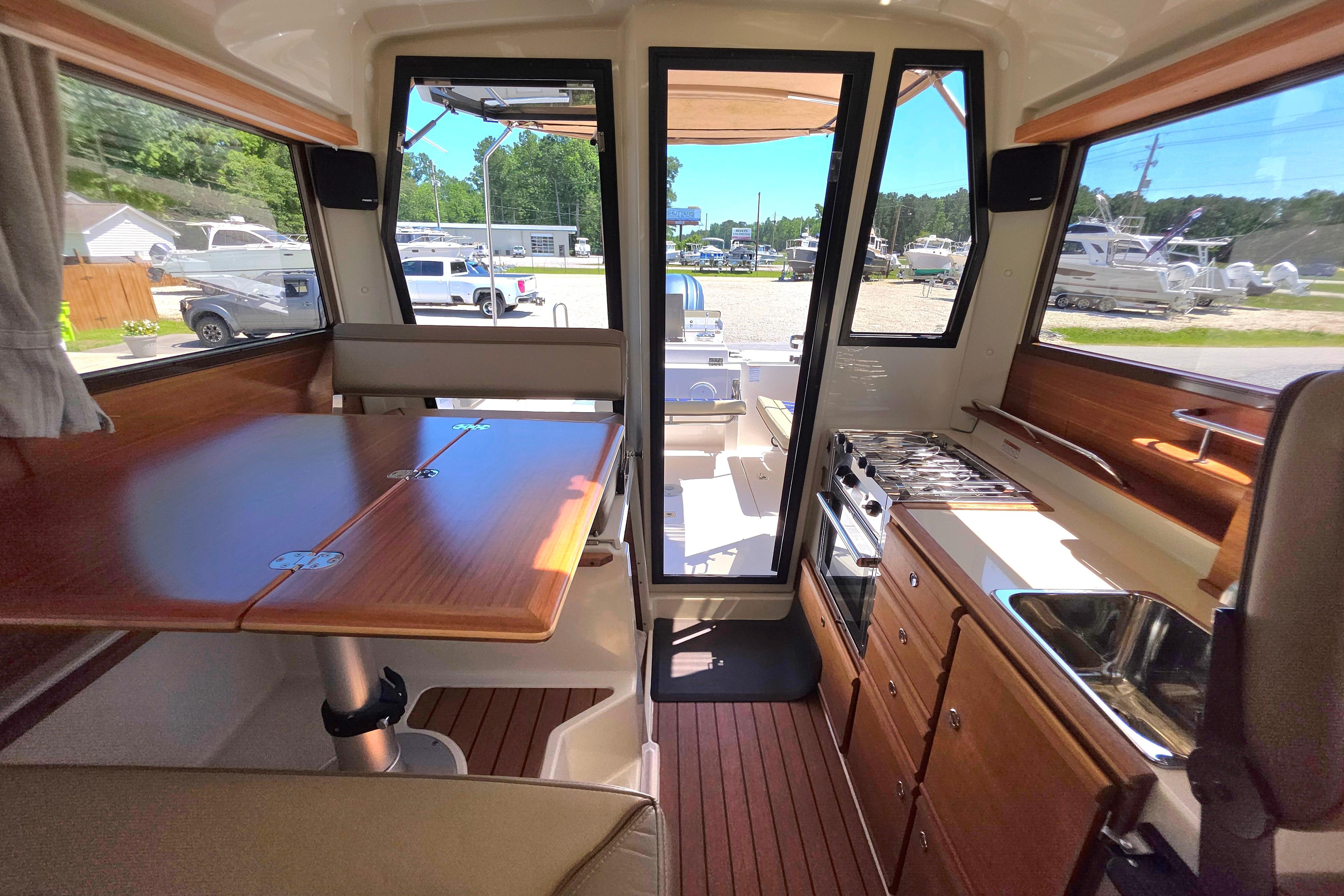 Interior of 2021 Ranger Tug R27 boat with dining area and kitchenette.