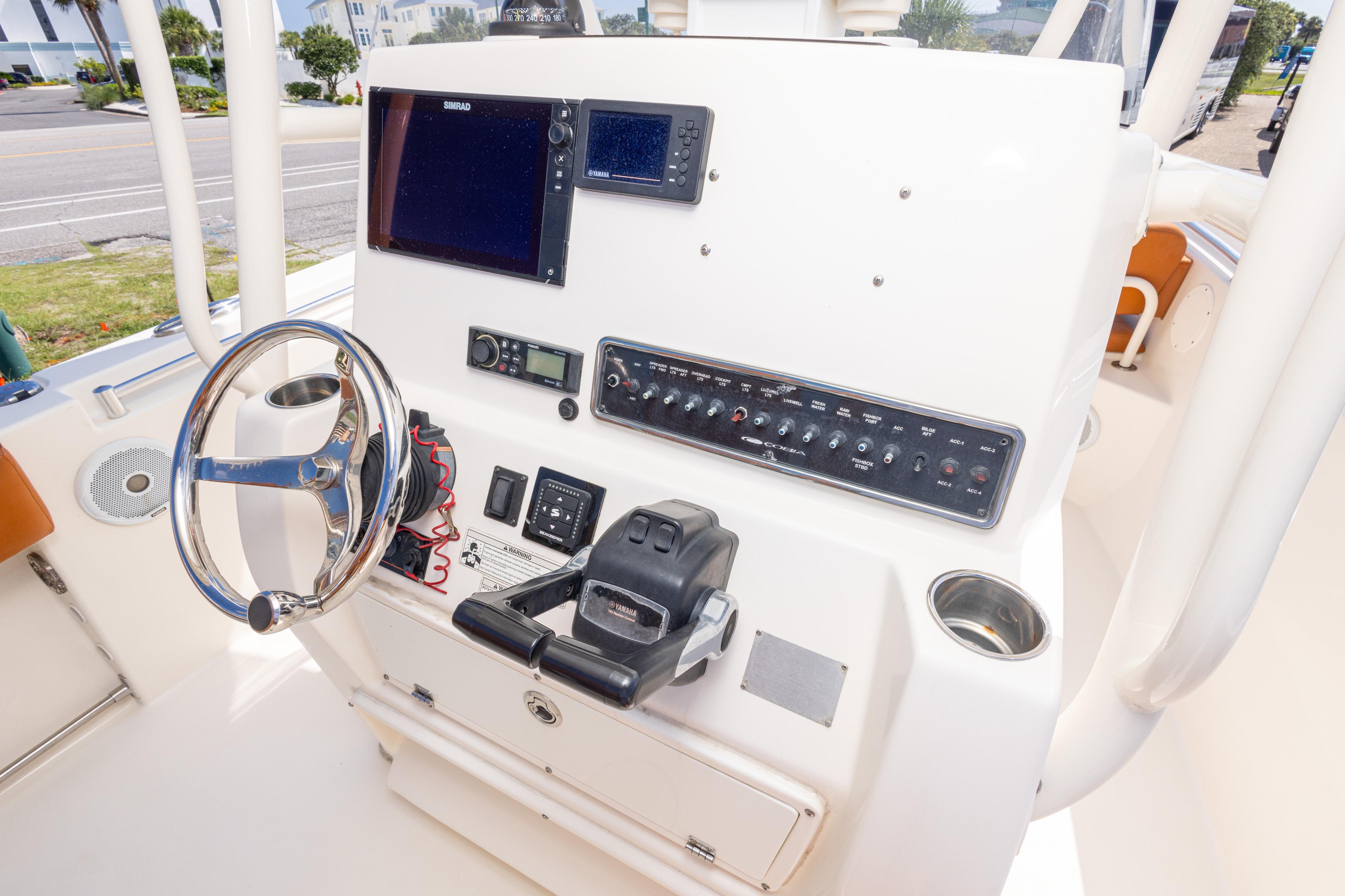 2017 Cobia 261 Center Console helm with steering wheel, controls, and navigation equipment.
