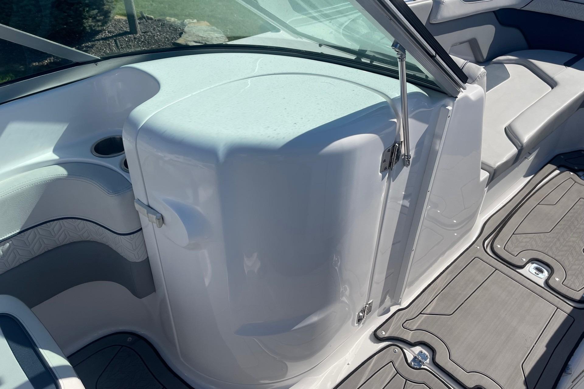2023 Hurricane SunDeck 2400 OB interior with seating and storage compartment.