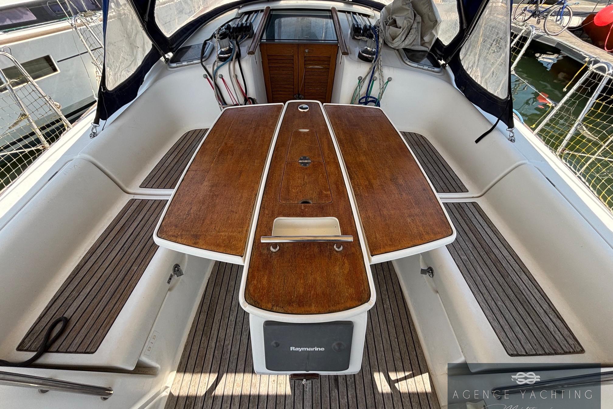 Cockpit of 2008 Beneteau Oceanis 40 sailboat with wooden table and seating.
