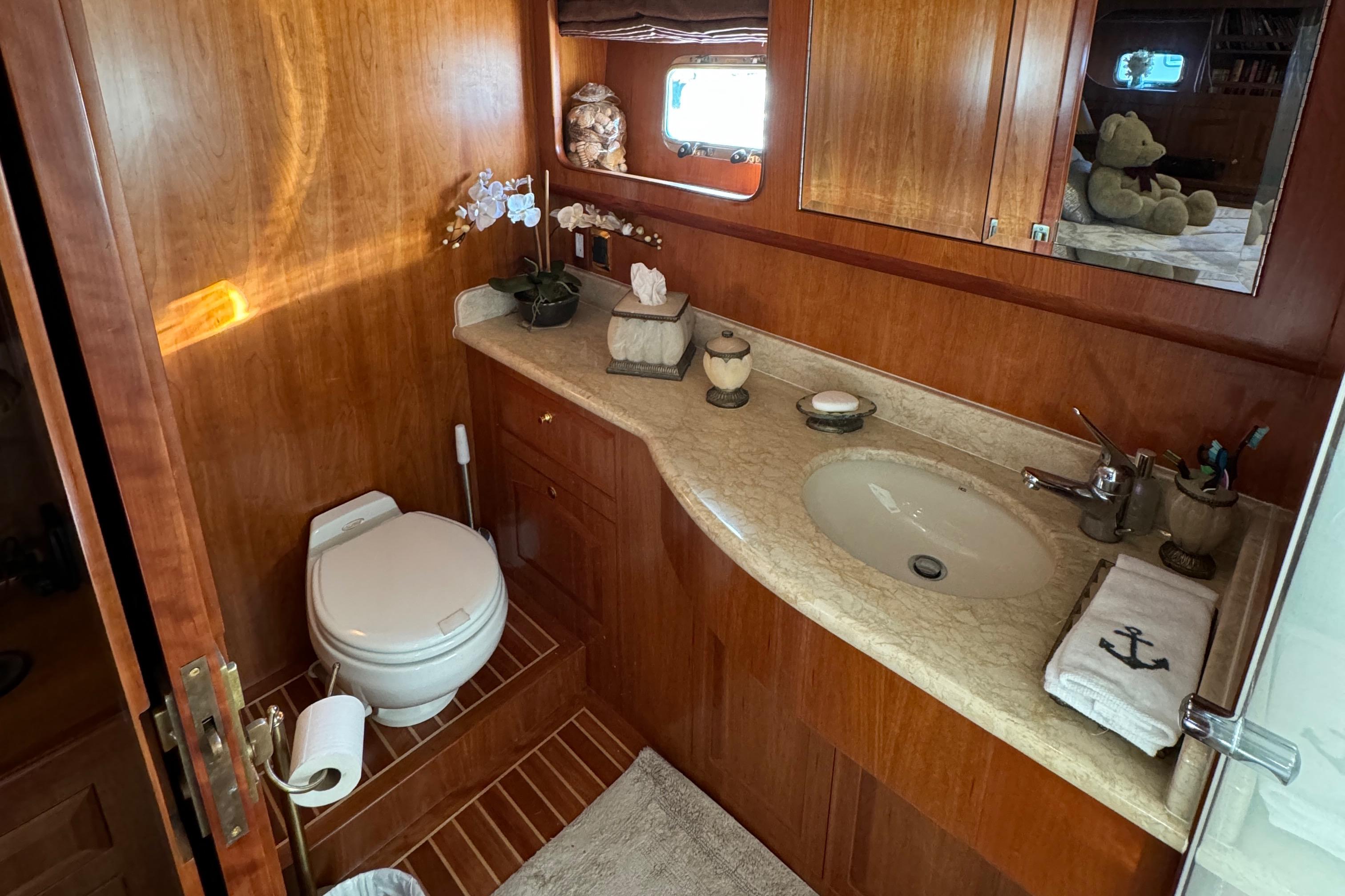Luxurious bathroom in 2006 President 63 Pilot House yacht with wooden cabinetry and elegant fixtures.