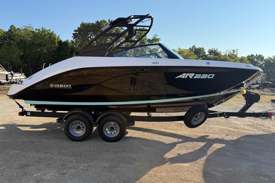 2026 Yamaha Boats AR220 on trailer, sleek black design, parked outdoors.