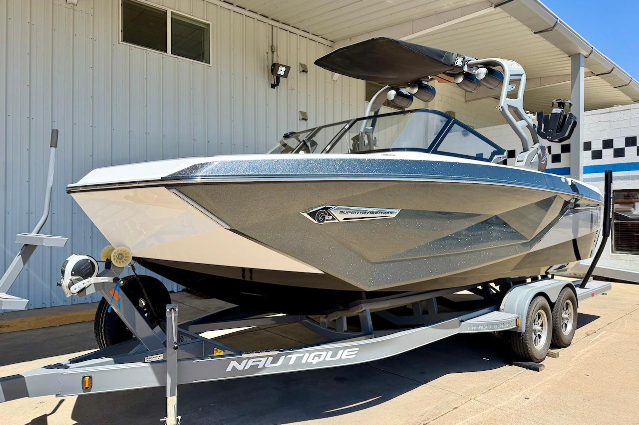 2021 Nautique Super Air Nautique G23 boat on trailer, parked outside a building.