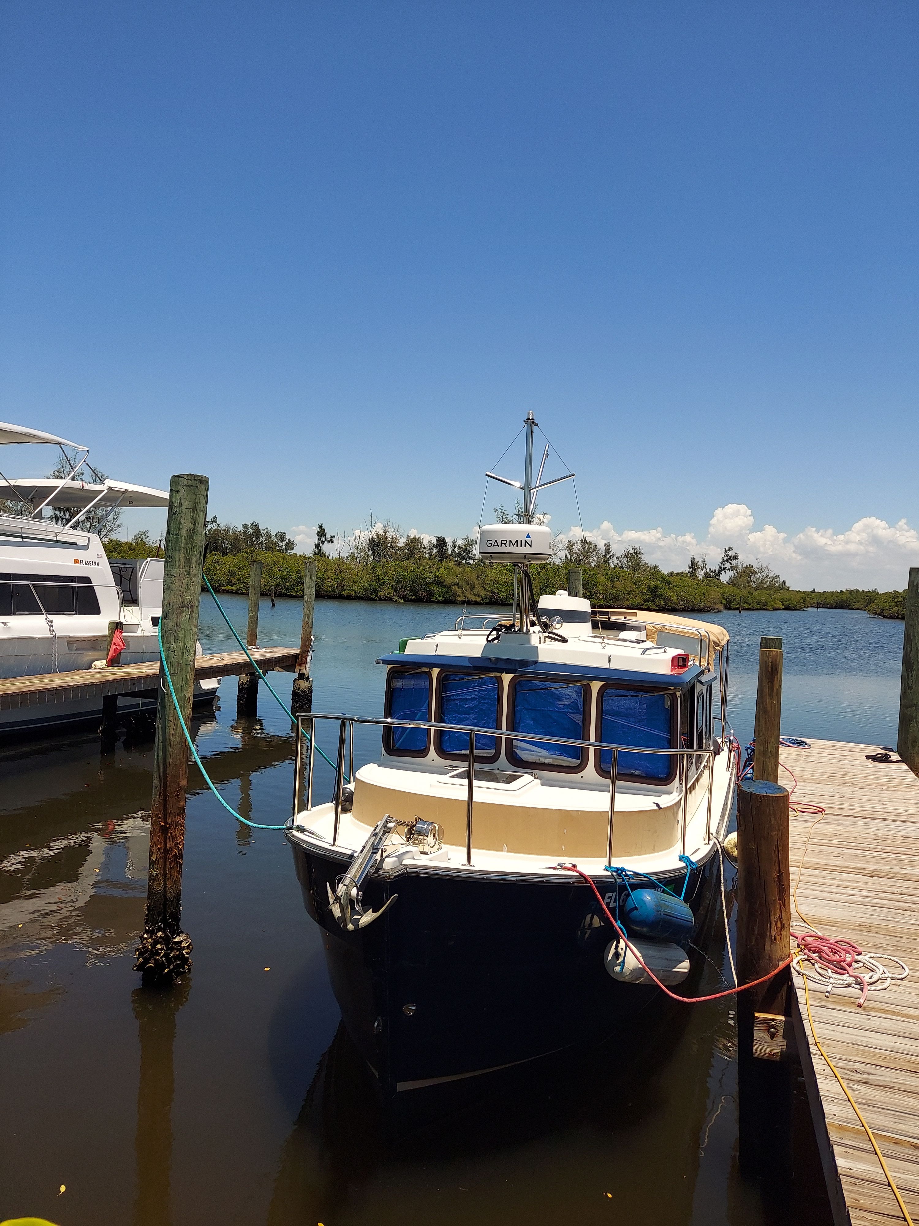 A 2011 Ranger Tugs R-25 SC is docked in calm water.
