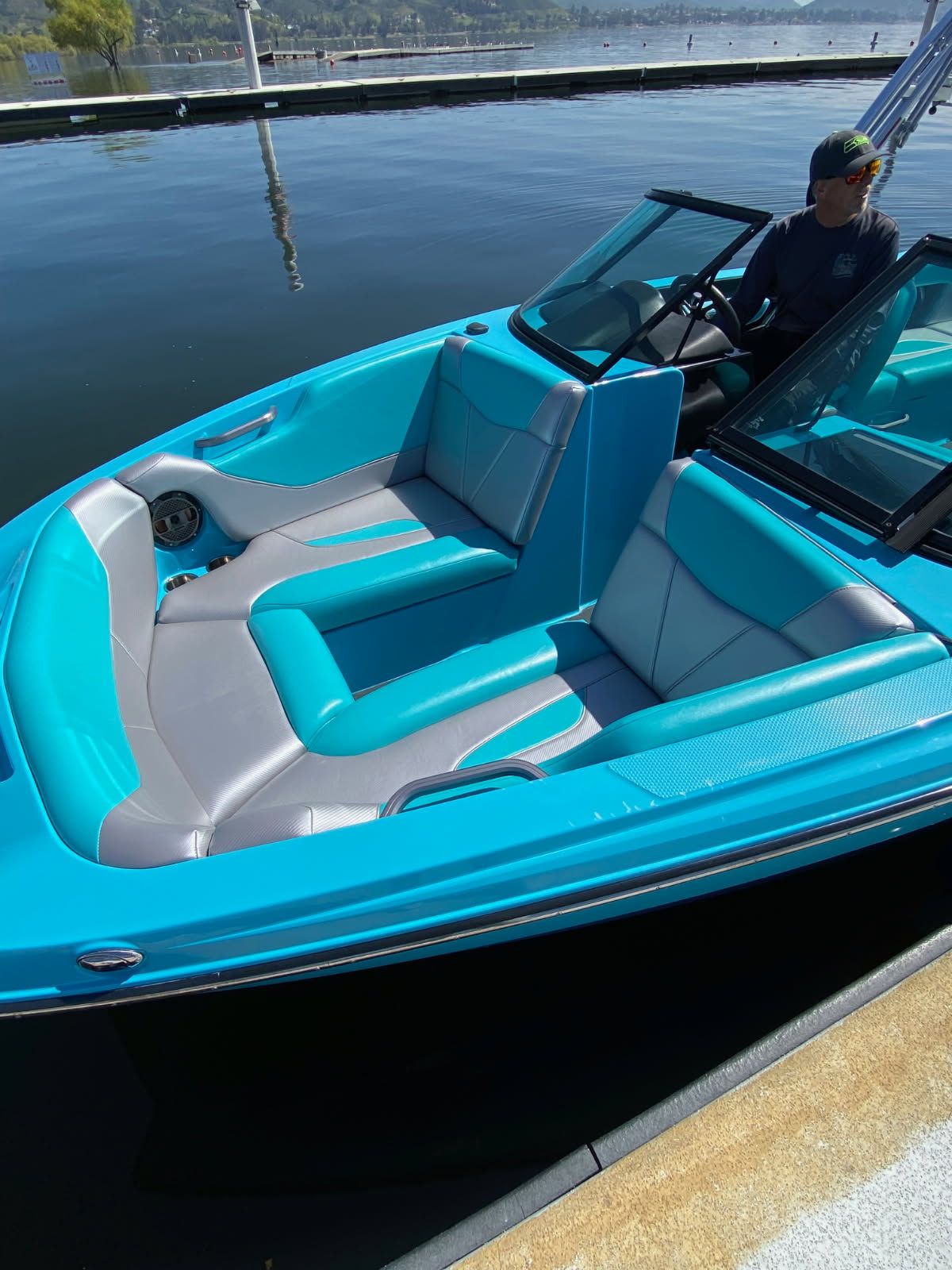 2021 MasterCraft NXT22 boat with turquoise interior at the dock.