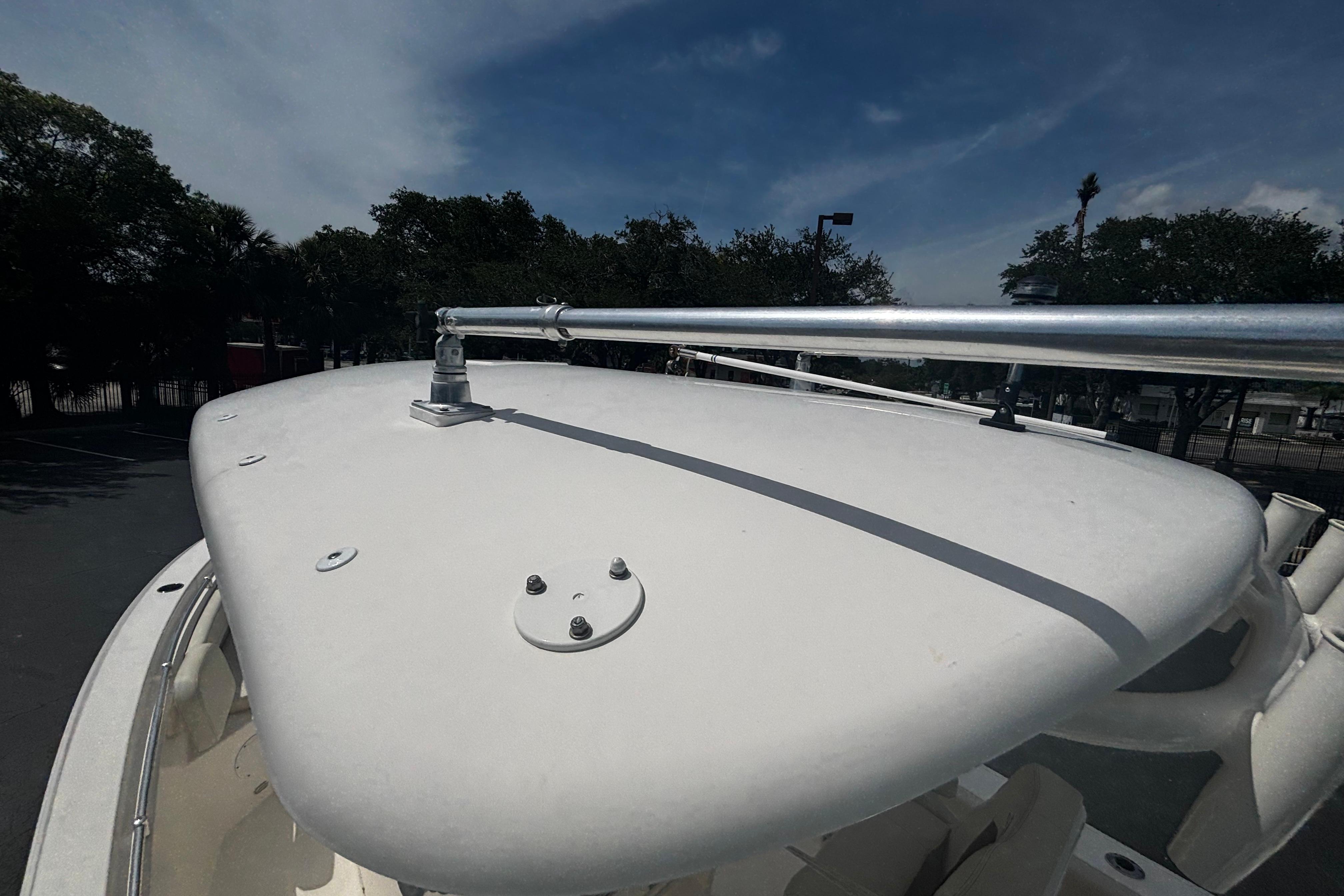 2023 Cobia 262 Center Console boat with T-top under a clear blue sky.