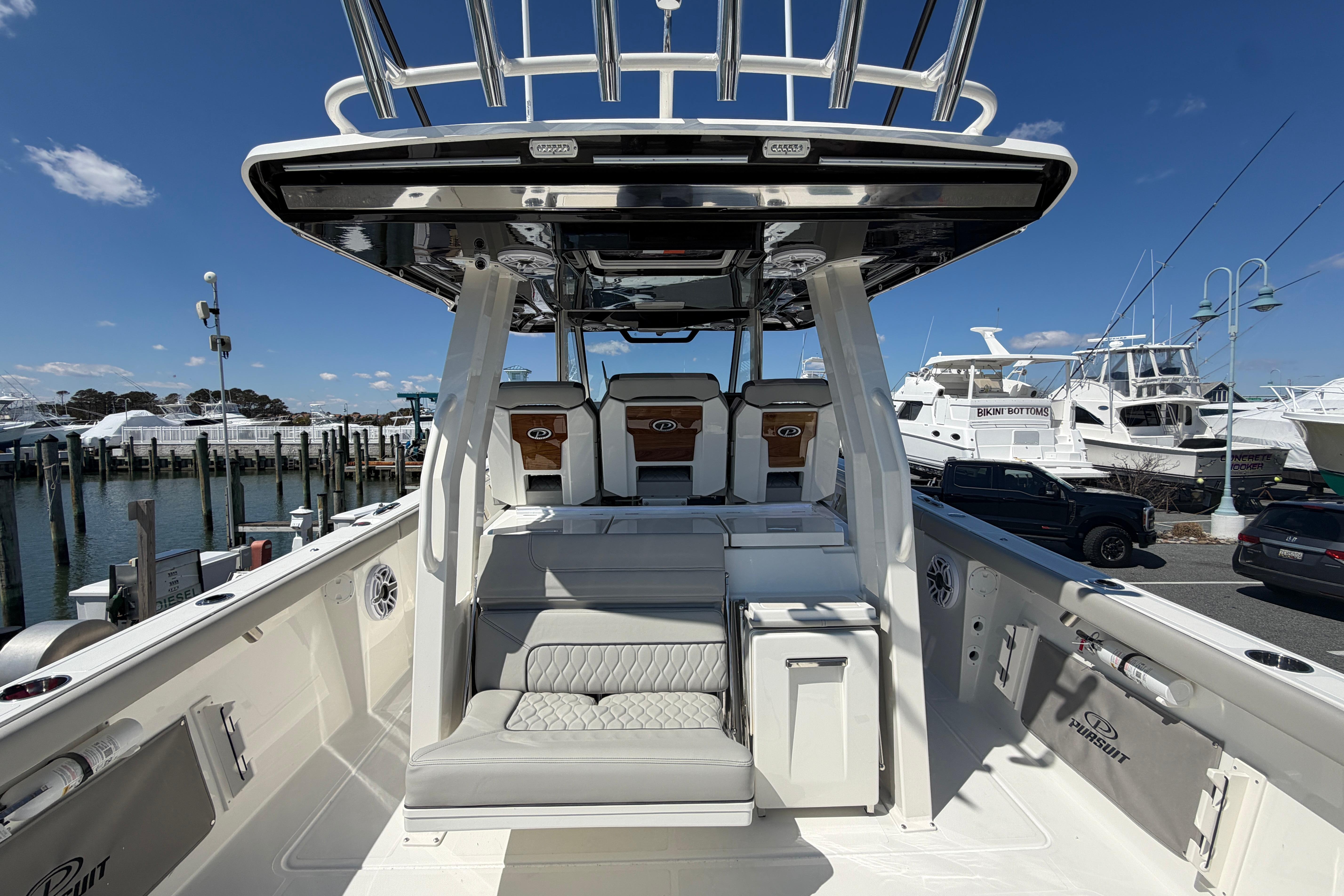 2026 Pursuit S 358 Sport boat interior at marina, showcasing seating and helm.