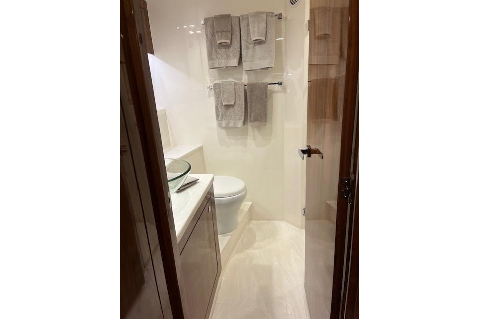 Luxurious bathroom in 2023 Riviera 5400 Sport Yacht with modern fixtures and elegant design.