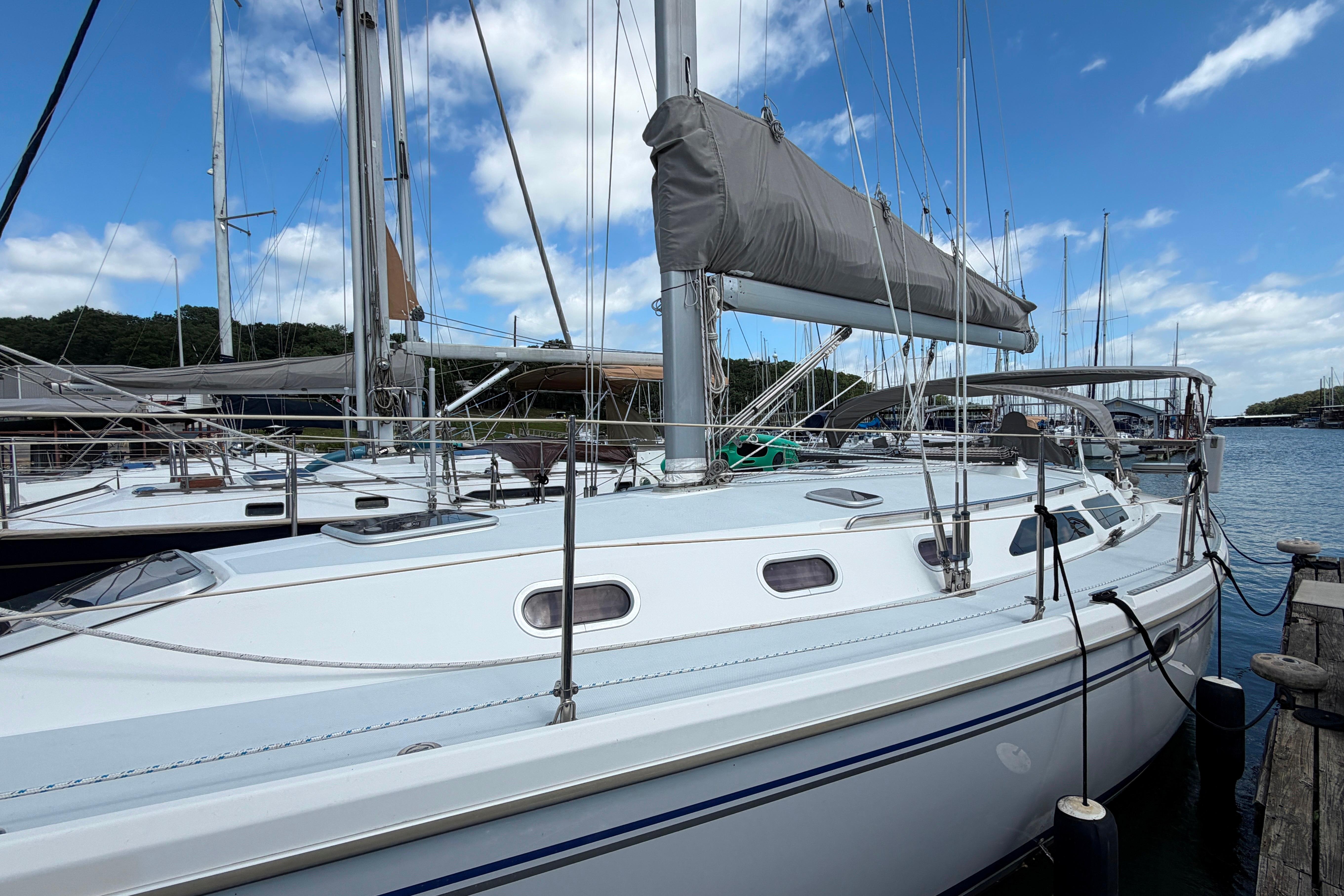 2001 Catalina 42 MkII sailboat docked at marina under blue sky.