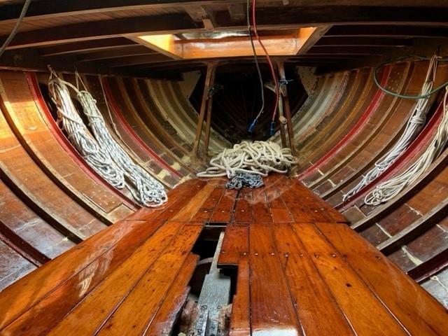 Interior of 1935 Custom 44' 30-Square Meter Sailing Yacht with wooden planks and coiled ropes.